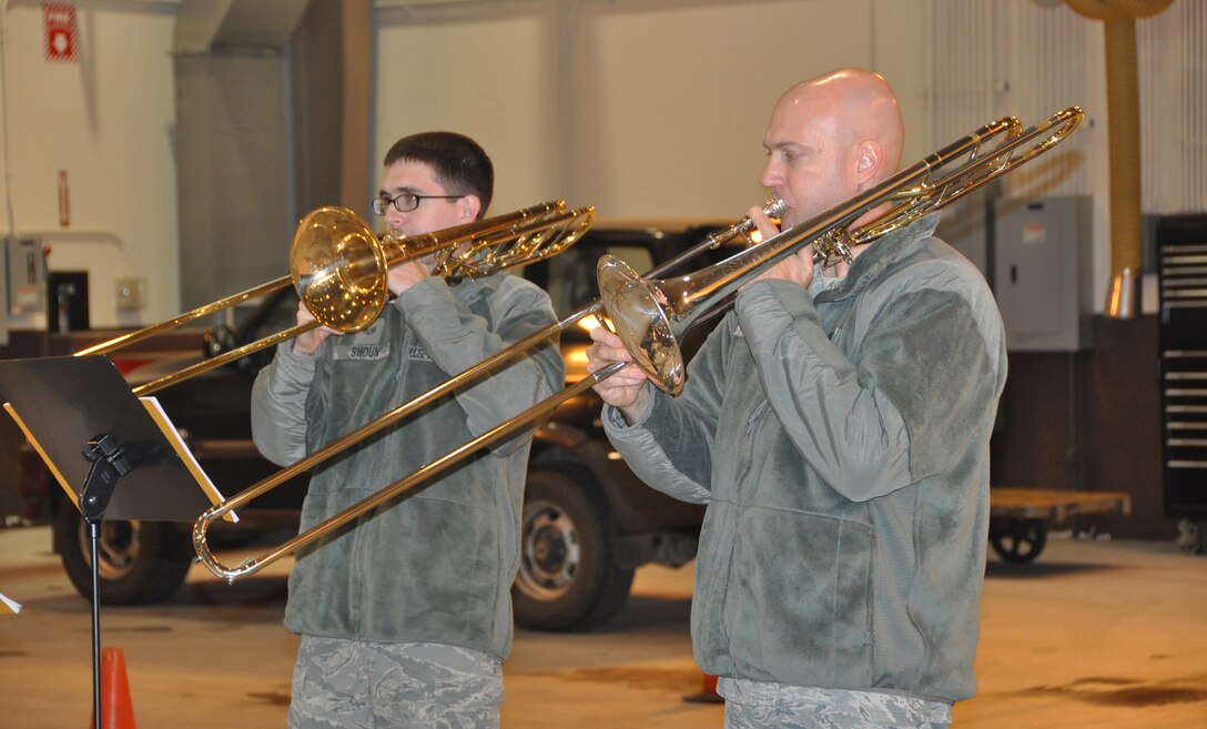 Tech. Sgt. Jason Foster and Senior Airman Mark Shoun, with the United States Air Force Band of the Pacific-Asia, play their trombones for 51st Logistics Readiness Squadron vehicle maintenance Airmen, Dec.12, 2012. The band made various stops on Osan Air Base to bring holiday cheer and play Christmas music. (U.S. Air Force photo/Senior Airman Kristina Overton)