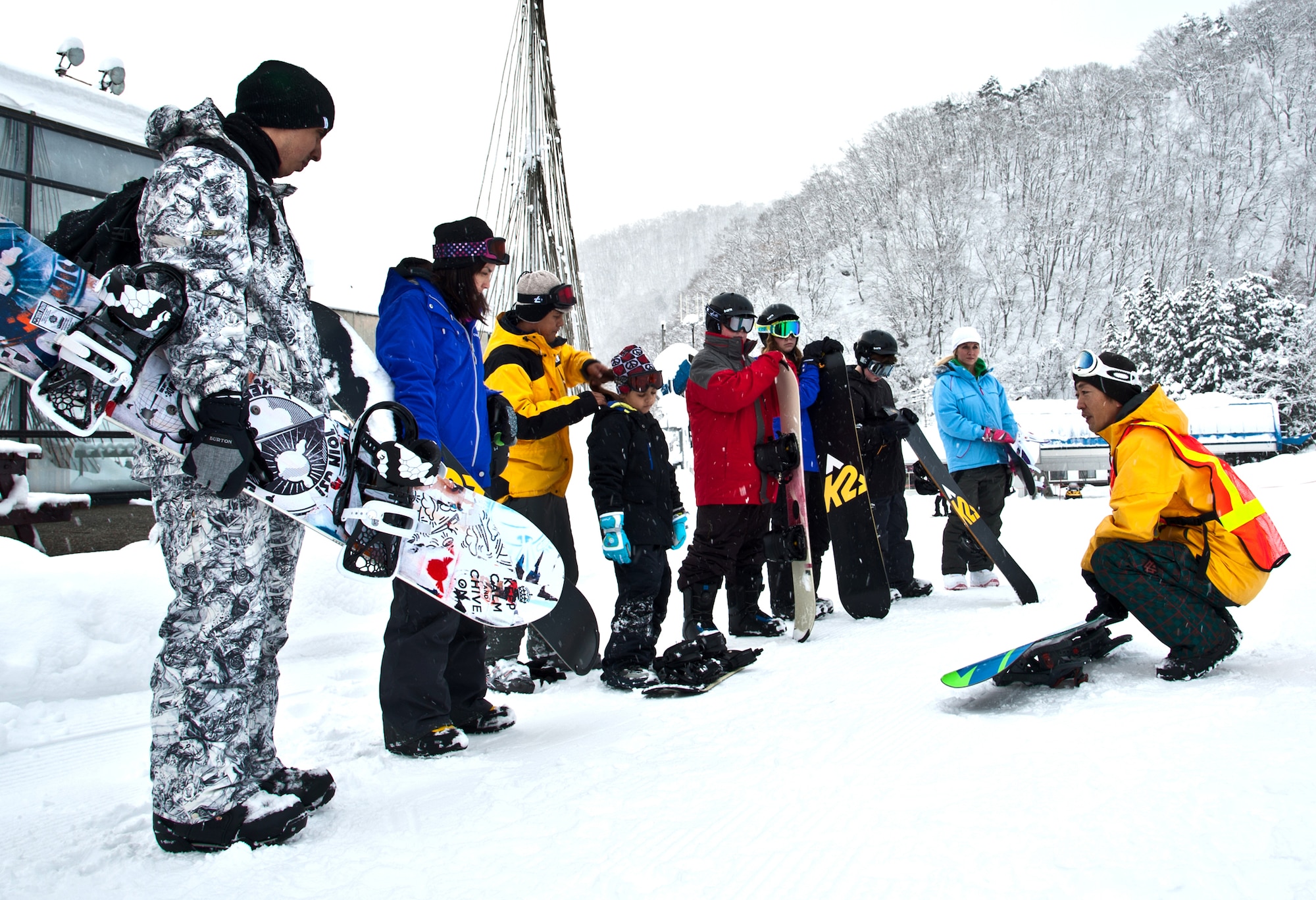 HAKUBA, Japan. -- Takashi Yoshii, 374th Force Support Squadron Outdoor Recreation tour guide, leads a group of amateur snowboarders away from a ski-lift ticket booth Dec. 12, 2012, during a ski trip. Yoshii has been snowboarding for more than 17 years and led a snowboarding course that taught basic skills to Yokota community members.  (U.S. Air Force photo/Senior Airman Cody H. Ramirez)