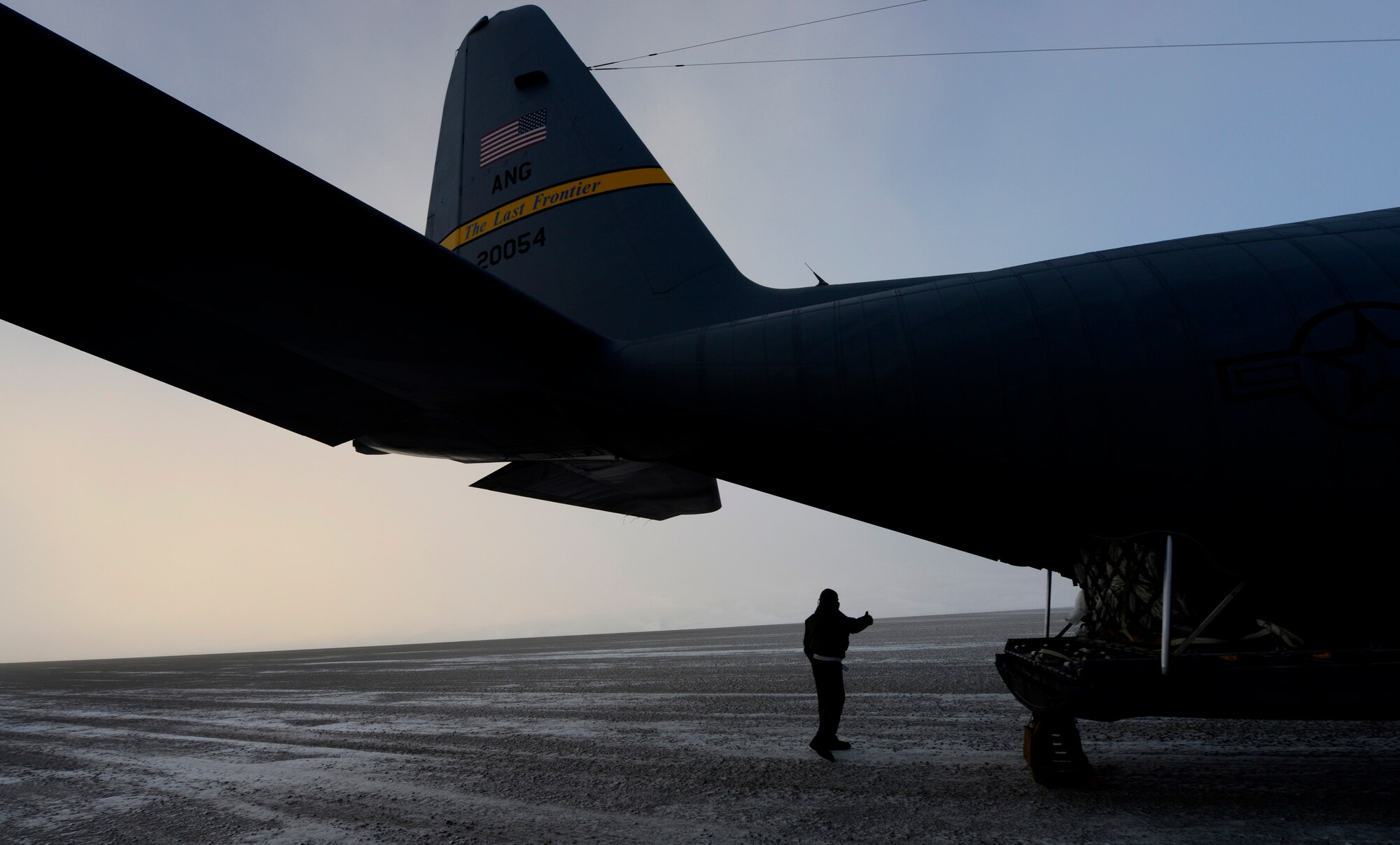 Airman 1st Class Andrew Thompson gives a thumbs up to a fork lift driver, signaling they are ready to off-load cargo at Cape Romanzof, Alaska, Dec.4. Cape Romanzof is a radar site which is part of the North Warning System, a 2,983-mile long and 199-mile wide "tripwire" stretching from Alaska, through Canada, to Southern Labrador. The radar sites cannot operate without these resupply missions, as many of the sites have no roads in or out. Thompson is a loadmaster assigned to the 537th Airlift Squadron. (U.S. Air Force photo/Tech Sgt. Brian Ferguson)