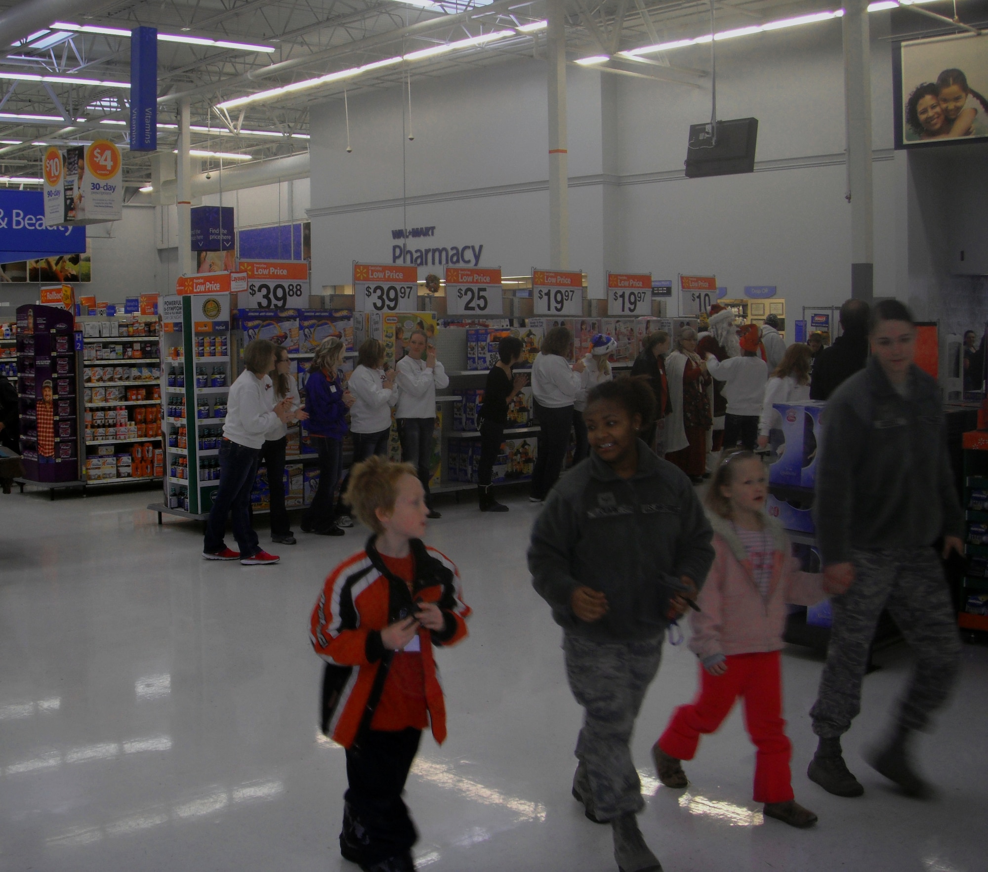 U.S. Air Force Airmen from Mountain Home Air Force Base, Idaho, walk with children at the local Wal-Mart Dec. 1, 2012, during the 16th Annual Shop with a Cop event. More than 115 children were able to purchase gifts for themselves and their families thanks to the efforts of various donations. (Courtesy photo)