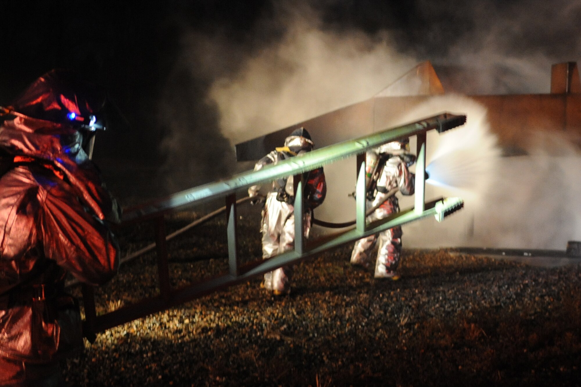 Airmen from the 633rd Civil Engineering Squadron rush to extinguish flames from a simulated-plane fire during a phase I combined unit exercise at Langley Air Force Base, Va., Dec. 12, 2012. The fire fighters were the first to respond to the incident. (U.S. Air Force photo by Senior Airman Racheal E. Watson/Released)