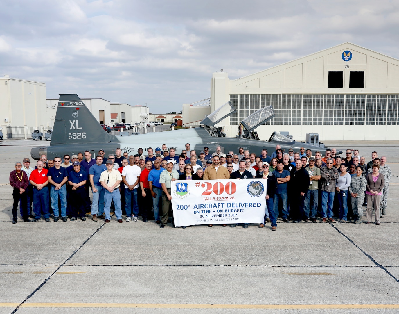 Members of the 571st Aircraft Maintenance Squadron Operating Location A team celebrate a production milestone Nov. 29, completing on-time, on-budget modifications to the 200th aircraft that has come out of their depot at Joint Base San Antonio- Randolph since it became a government facility. (U.S. Air Force photoby Joshua Rodriguez)