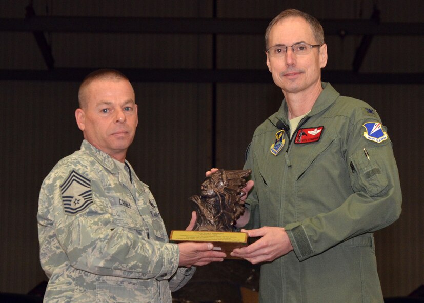 Chief Master Sgt. Paul Carney, representing the 131st Bomb Wing Chiefs Council, presents the Honorary Chief Master Sgt. Award to 131st Bomb Wing commander, Col Greg Champagne.  The presentation was held during the annual Wing All Call, Dec 9, at Whiteman AFB.  (National Guard Photo by Staff Sgt.Sean Navarro)