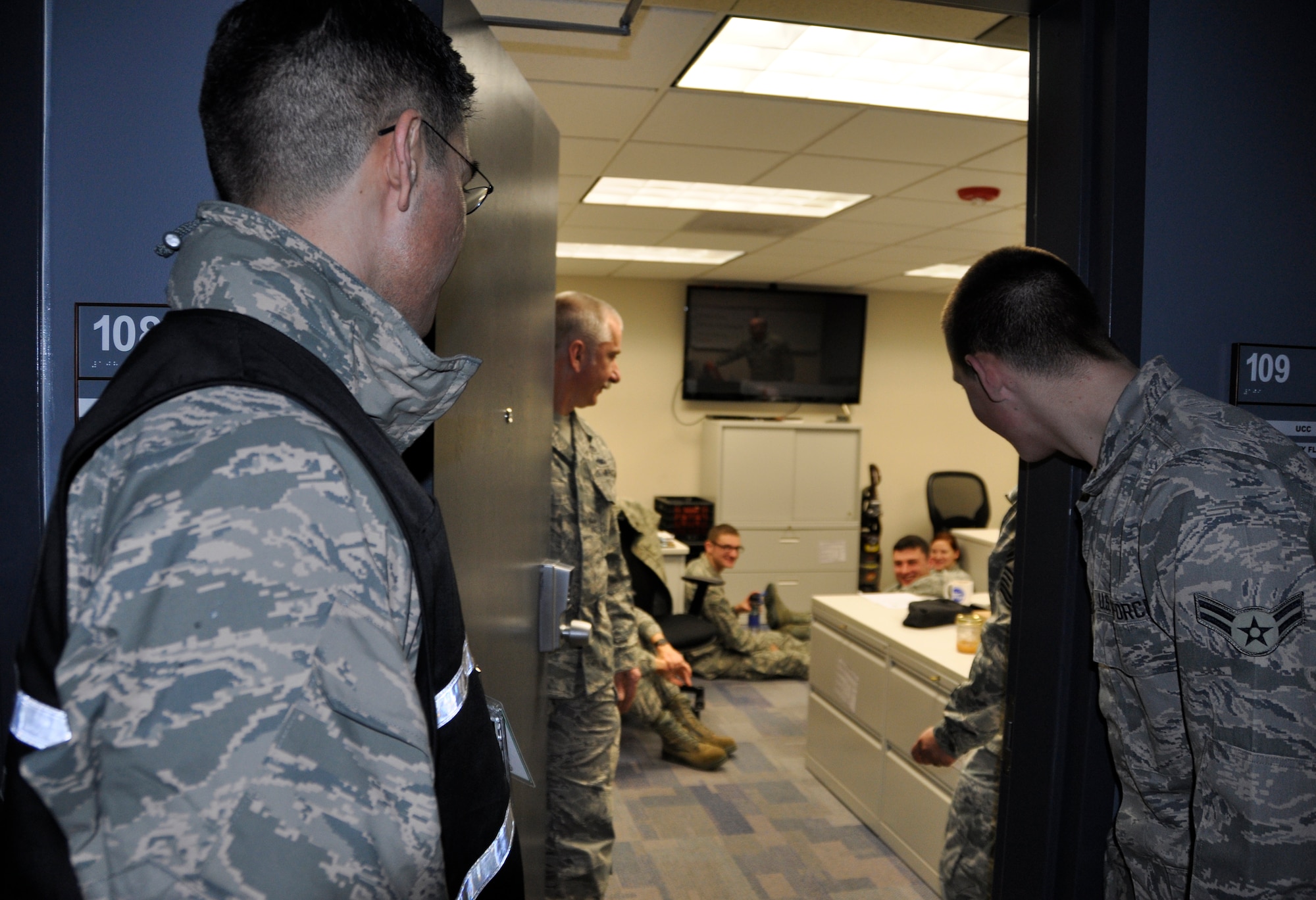 Lt. Col. Ray Luevanos (left), 446th Mission Support Group deputy commander and Exercise Evaluation Team member, looks in on members of the 446th Civil Engineer Squadron who are taking shelter during a Force Protection Exercise on Joint Base Lewis-McChord Dec. 12. The exercise is part of an annual Installation Management Command requirement to ensure JBLM has the capability to respond to various security threats. (U.S. Air Force Photo/Staff Sgt. Rachael Garneau)