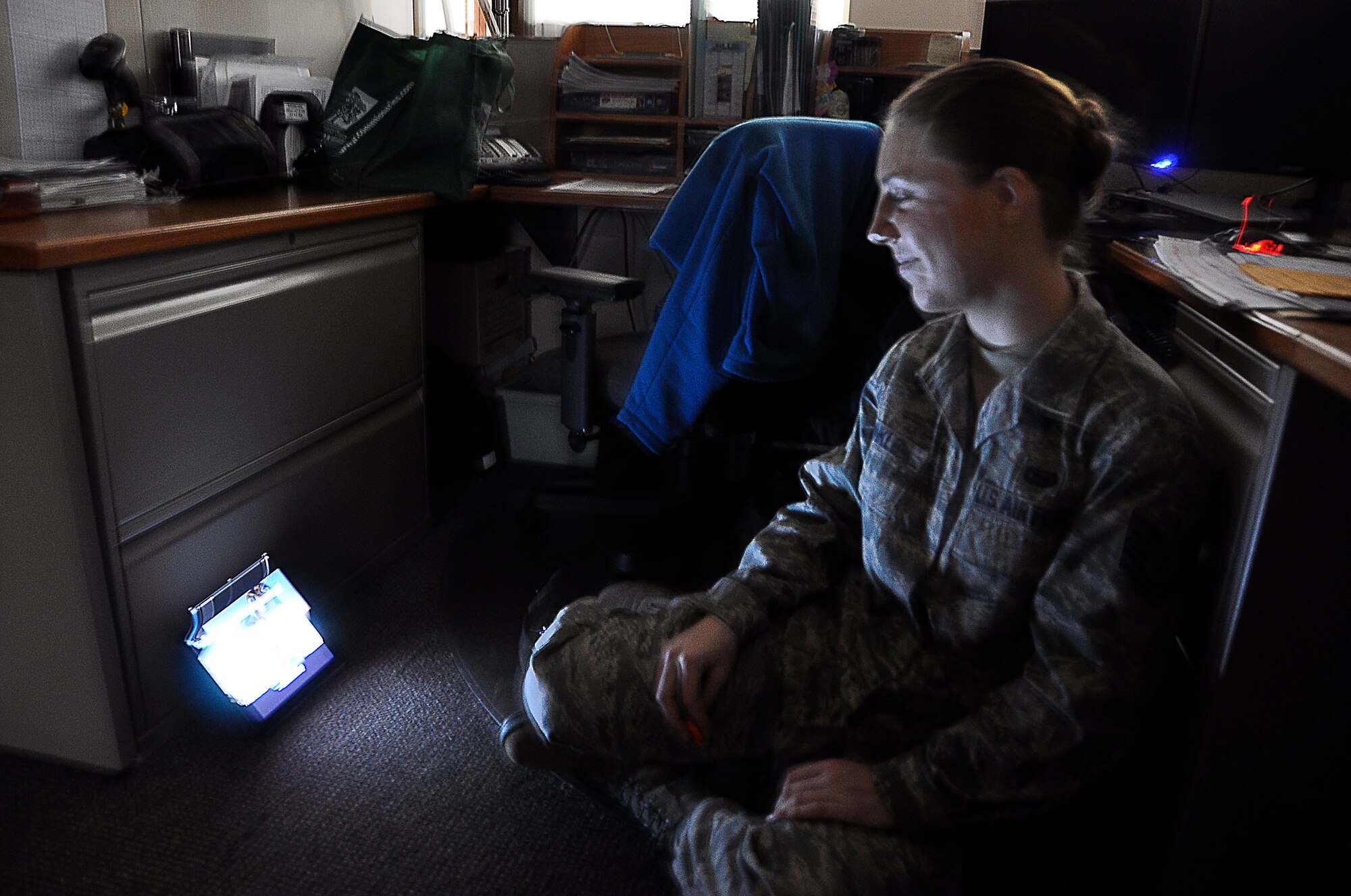 Tech. Sgt. Carlee Hinkle, 446th Force Support Squadron command staff NCO in charge, takes shelter inside her office during a Force Protection exercise here Dec. 12. The exercise is part of an annual Installation Management Command requirement to ensure Joint Base Lewis-McChord has the capability of responding to various security threats. (U.S. Air Force Photo/Staff Sgt. Rachael Garneau)