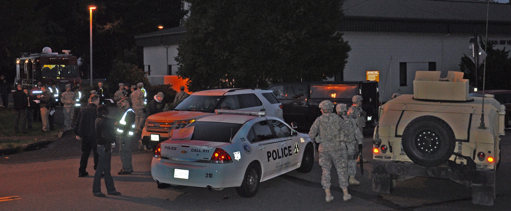 Emergency response crews from Joint Base Lewis-McChord gather in response to a Force Protection exercise scenario at the 446th Airlift Wing Headquarters building here Dec. 12. The exercise is part of an annual Installation Management Command requirement to ensure JBLM has the capapability to respond to various security threats. (U.S. Air Force Photo/Staff Sgt. Rachael Garneau)