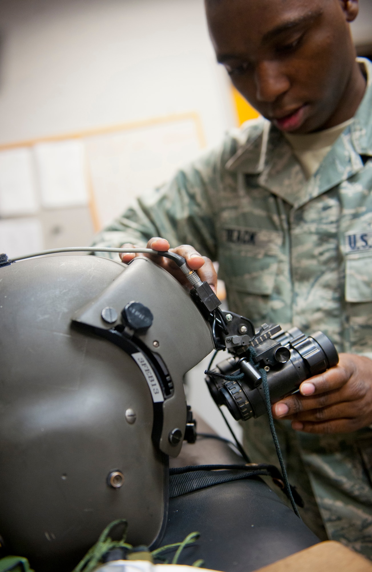 U.S. Air Force Airman 1st Class Mitchell Black, 347th Operations Support Squadron aircrew flight equipment (AFE) technician, attaches night vision goggles to a helmet at Moody Air Force Base, Ga., Dec. 6, 2012. AFE regularly inspects every item to ensure it is in working order. (U.S. Air Force photo by Airman 1st Class Jarrod Grammel/Released)
