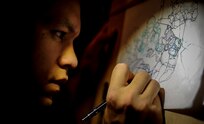 Airman 1st Class John Yurcaba IV, 1st Combat Camera Squadron broadcaster, draws a comic book fight scene. Yurcaba grew up reading comic books and watching cartoons on television and has derived much of his inspiration from them. (U.S. Air Force photo/ Senior Airman Dennis Sloan)