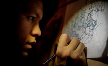 Airman 1st Class John Yurcaba IV, 1st Combat Camera Squadron broadcaster, draws a comic book fight scene. Yurcaba grew up reading comic books and watching cartoons on television and has derived much of his inspiration from them. (U.S. Air Force photo/ Senior Airman Dennis Sloan)