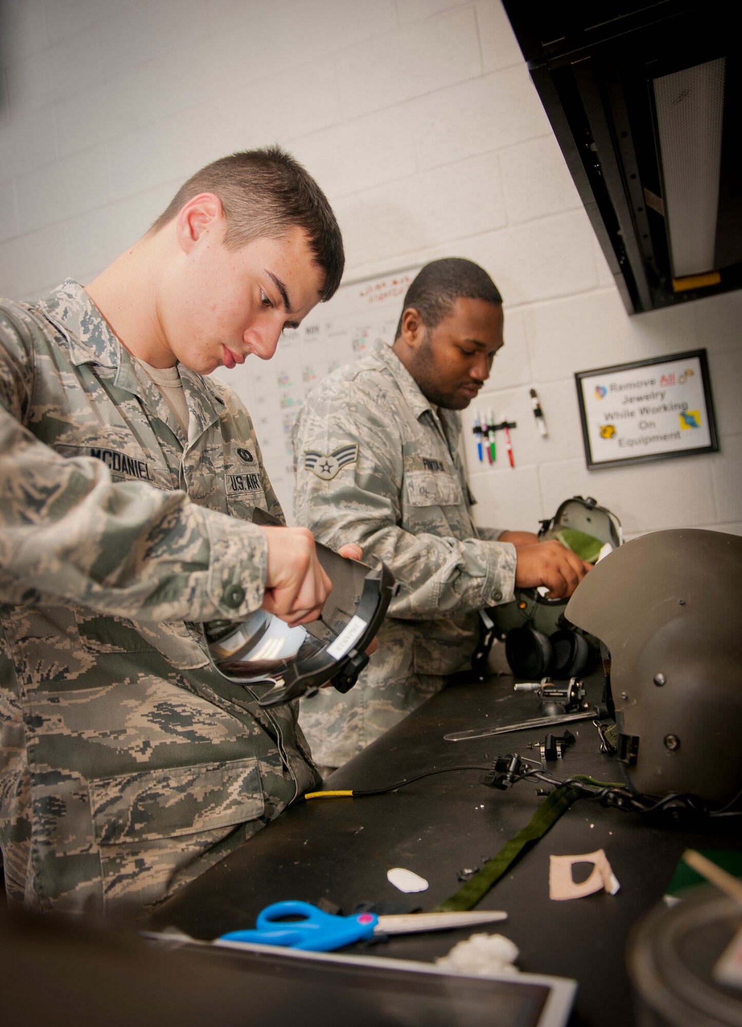 U.S. Air Force Airman 1st Class Jared McDaniel and Senior Airman Roderick Fountain, both aircrew flight equipment (AFE) technicians with the 347th Operations Support Squadron, work on aircrew helmets at Moody Air Force Base, Ga., Dec. 6, 2012. Although assigned to the 347th OSS, McDaniel and Fountain primarily work primarily in the 41st Rescue Squadron on equipment for HH-60G Pave Hawk crews. (U.S. Air Force photo by Airman 1st Class Jarrod Grammel/Released)
