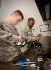 U.S. Air Force Airman 1st Class Jared McDaniel and Senior Airman Roderick Fountain, both aircrew flight equipment (AFE) technicians with the 347th Operations Support Squadron, work on aircrew helmets at Moody Air Force Base, Ga., Dec. 6, 2012. Although assigned to the 347th OSS, McDaniel and Fountain primarily work primarily in the 41st Rescue Squadron on equipment for HH-60G Pave Hawk crews. (U.S. Air Force photo by Airman 1st Class Jarrod Grammel/Released)
