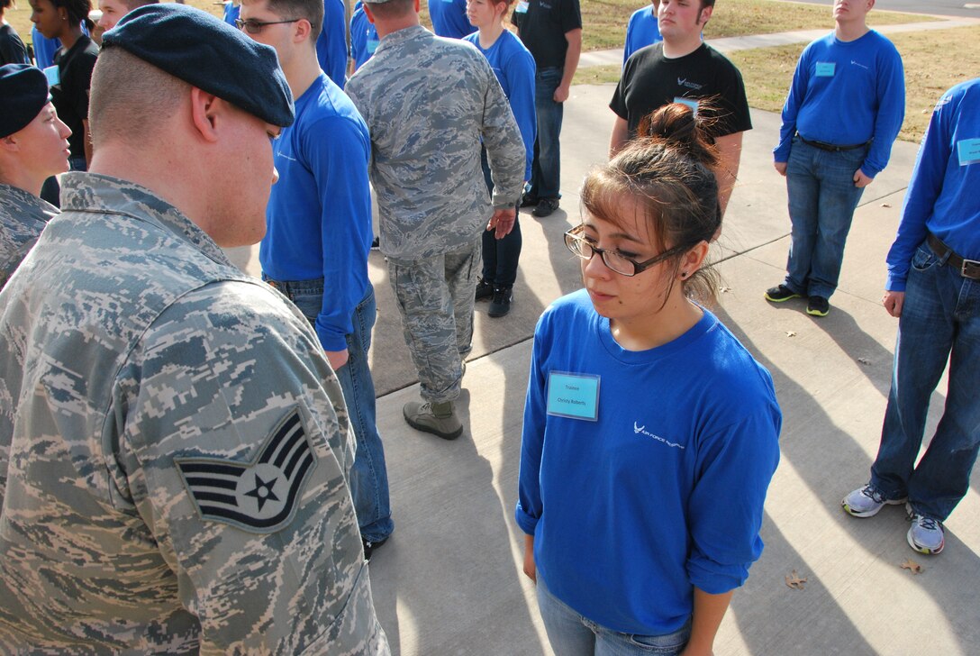 Staff Sgt. Jason Overstreet, 507th Security Forces Squadron, inspects Christy Roberts in front of the Airman Leadership School during December’s unit training assembly.  Roberts is one of the first candidates to take part in a new Air Force Reserve Command initiative that prepares newly enlisted recruits for the transition between the civilian life and the air force life.  (Photo by Senior Airman Mark Hybers)