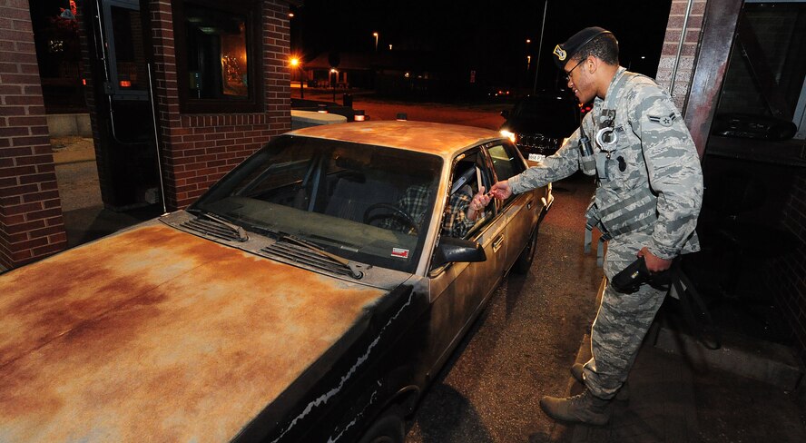 Airman 1st Class Paul Swanegan, 509th Security Forces Squadron security forces specialist, checks identification cards at Whiteman Air Force Base, Mo., Dec. 6. More than 12,000 people enter the gates on a daily basis.  (U.S. Air Force photo/Senior Airman Nick Wilson) (Released)