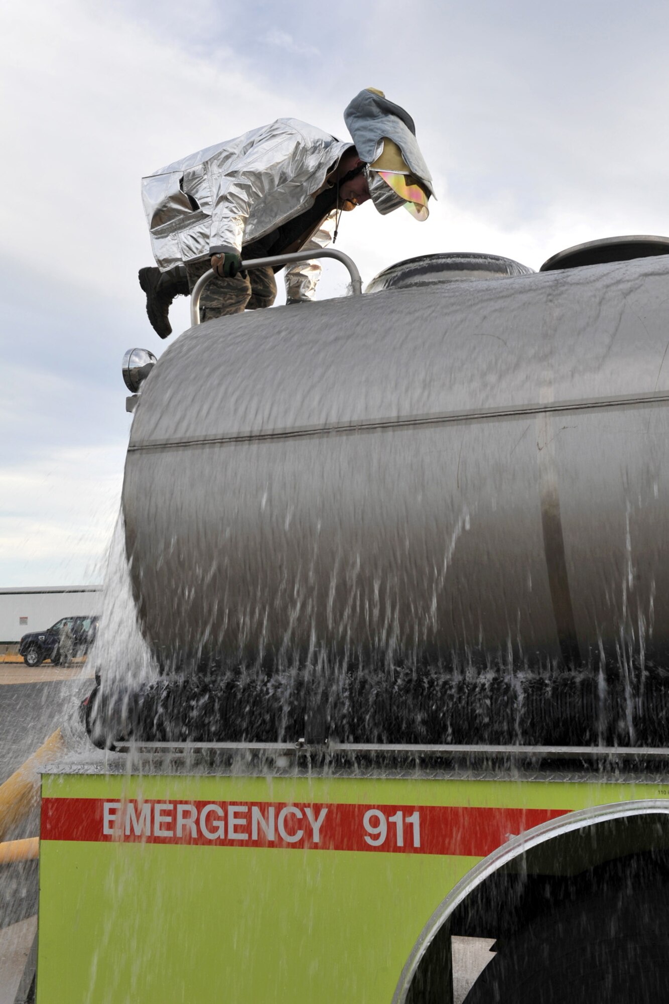 Airman 1st Class William Lawrence, Team Whiteman firefighter, climbs the back of a tanker to simulate a water re-supply operation Dec. 5 at Whiteman Air Force Base, Mo. The team is required to conduct upgrade training and exercises throughout the year to keep their skills up-to-date and mission-ready. (U.S. Air Force photo/Heidi Hunt) (Released)