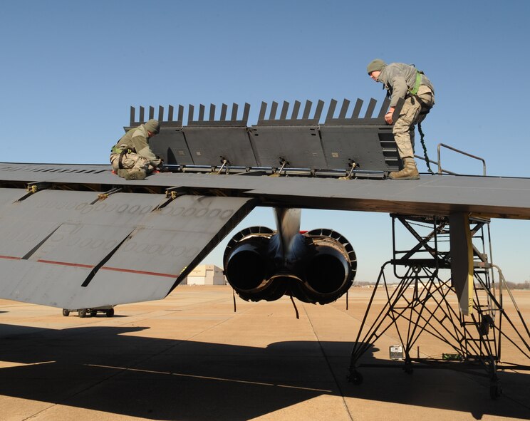 Airman 1st Class Weston Fleming, 11th Aircraft Maintenance Unit, lifts a speed-brake spoiler on the wing of a B-52H Stratofortress while Airman 1st Class Dillon Neth, 11 AMU, installs a spoiler lock on Barksdale Air Force Base, La., Dec. 12. The spoiler lock is installed for safety reasons to keep the spoiler up while inspections and maintenance is performed underneath. (U.S. Air Force photo/Airman 1st Class Benjamin Gonsier)