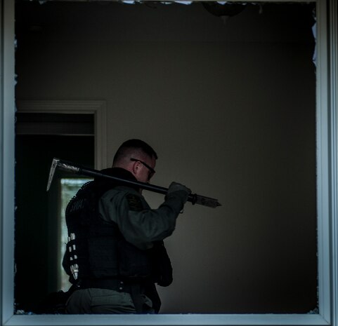 A Charleston County Sheriff’s Office Special Weapons and Tactics member tears blinds walks away from a shattered the window he cleared of all glass during a hostage extraction training exercise Dec. 6, 2012, at vacant housing on Joint Base Charleston – Air Base, S.C. The SWAT team provides a coordinated response to critical incidents throughout Charleston County, and whenever requested, in other areas throughout the state of South Carolina. (U.S. Air Force photo/ Senior Airman Dennis Sloan)