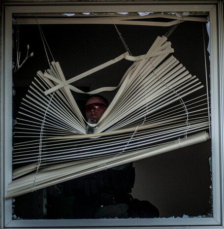 A Charleston County Sheriff’s Office Special Weapons and Tactics member tears blinds down after a flash bang went off in the room and shattered the window during a hostage extraction training exercise Dec. 6, 2012, at vacant housing on Joint Base Charleston – Air Base, S.C. The SWAT team provides a coordinated response to critical incidents throughout Charleston County, and whenever requested, in other areas throughout the state of South Carolina. (U.S. Air Force photo/ Senior Airman Dennis Sloan)