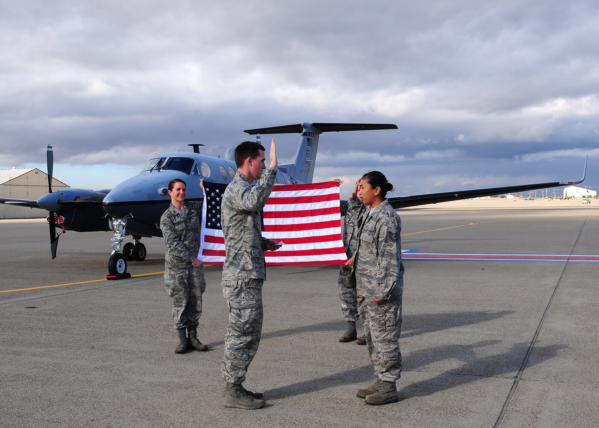 Tech. Sgt. Michelle Aquino (right) re-enlists on the 12th month on the 12 day of 2012 at 12:12 p.m. in front of an Air Force MC-12W Liberty intelligence, surveillance and reconnaissance aircraft at Beale Air Force Base, Calif. Aquino is a 9th Force Support Squadron personnelist who has served in the Air Force for 10 years. (U.S. Air Force photo by Senior Airman Shawn Nickel/Released)