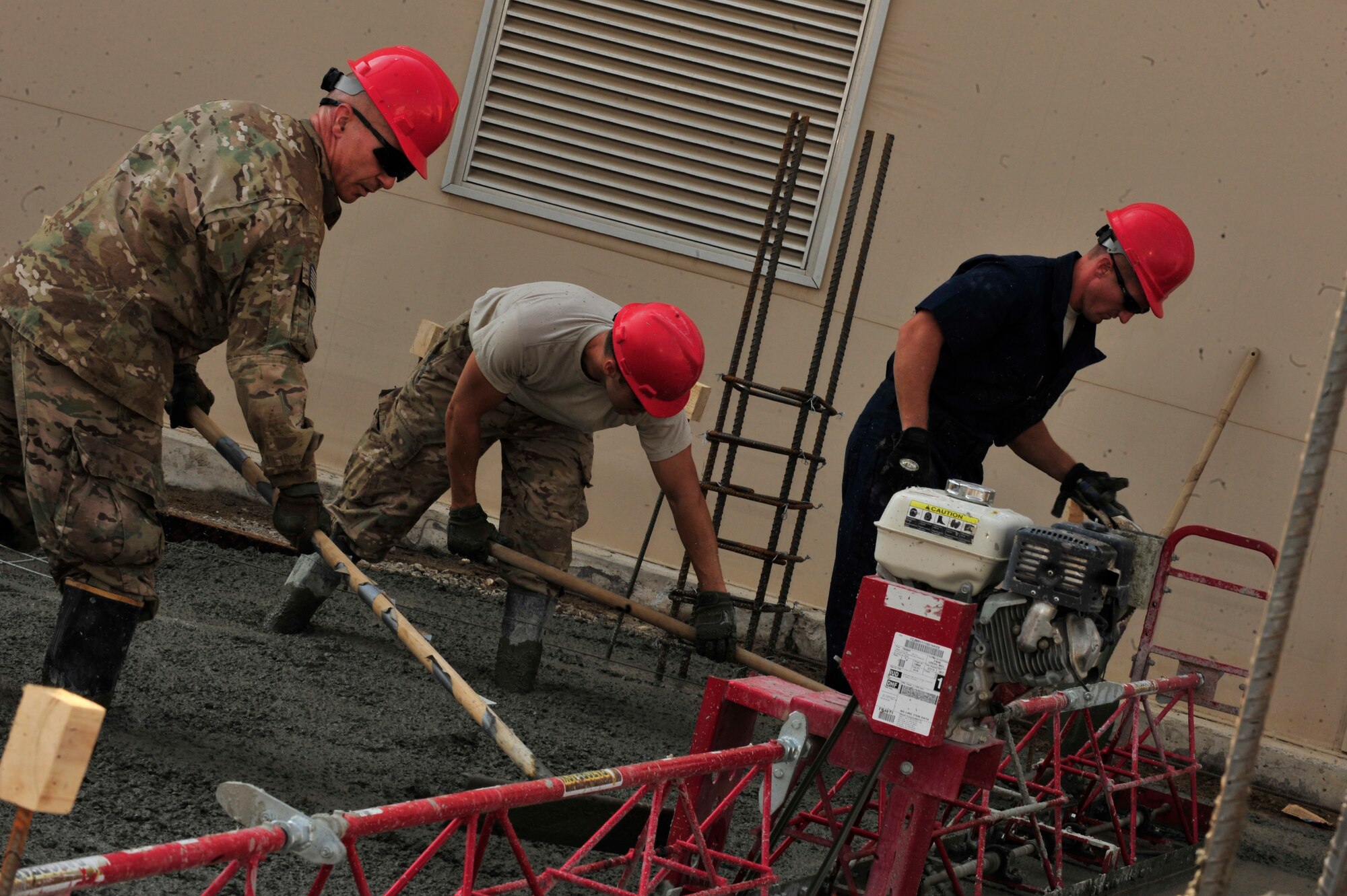 SOUTHWEST ASIA -- U.S. Air Force Staff Sgts. Brett Usury and Jeffery Lyons, and Senior Airman Dominick Thompson, 560th RED HORSE Squadron Structures journeymen, lay the foundation of a two-story concrete-brick building Dec. 4, 2012. RED HORSE is comprised of 21 trades capable of constructing buildings and runways in contingency environments. (U.S. Air Force photo/Tech. Sgt. Christina M. Styer) (RELEASED)