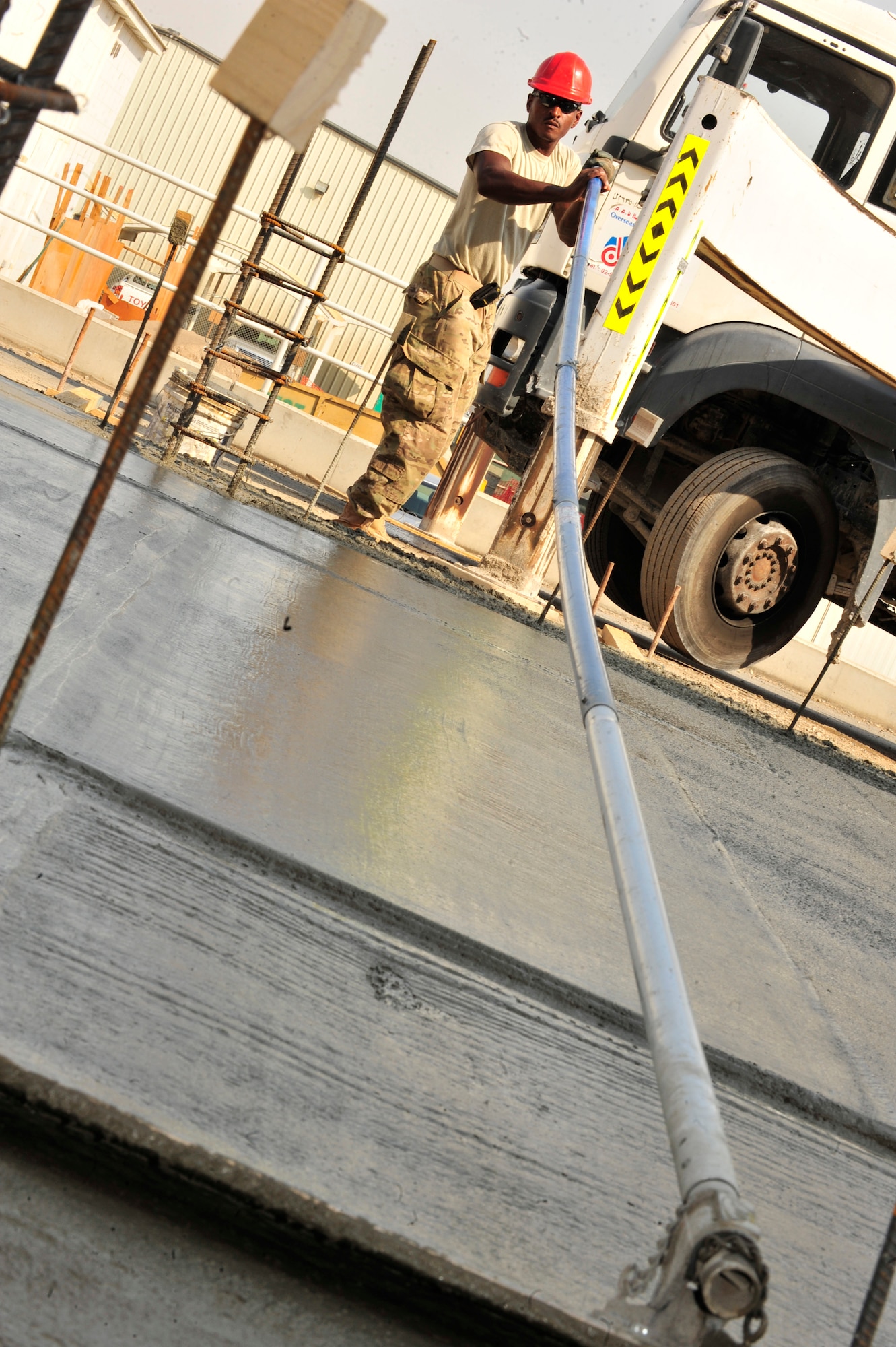 SOUTHWEST ASIA -- U.S. Air Force Staff Sgt. William Hyche, 560th RED HORSE Squadron DIRTBOY, smooths the concrete foundation for a two-story, concrete-block building Dec. 4, 2012. RED HORSE is an all-encompassing, fully self-supported unit designed for its building capabilities in contingency environments. (U.S. Air Force photo/Tech. Sgt. Christina M. Styer) (RELEASED)