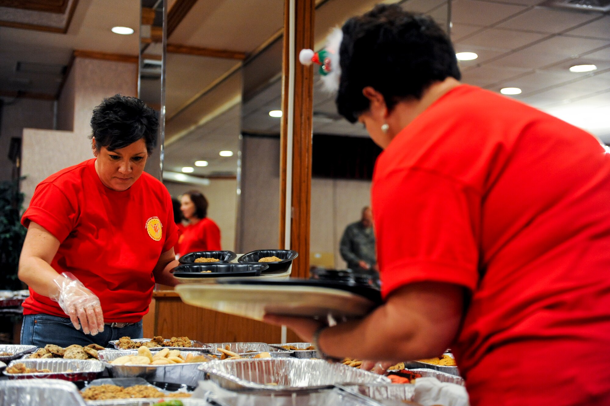 Shannon Jobe, wife of Chief Master Sgt. Melvin Jobe, 18th Munitions Squadron superintendent, and Tina Roy, wife of Chief Master Sgt. Gerald Roy, 18th Aircraft Maintenance Squadron maintenance superintendent, pick cookies to go into cookie trays for single service members on Okinawa, on Kadena Air Base, Japan, Dec. 11, 2012.  The cookie drive had 70 volunteers, including service members, chief’s spouses and members from the First Sergeants Association to help make this event a success. (U.S. Air Force photo/Airman 1st Class Justin Veazie)
