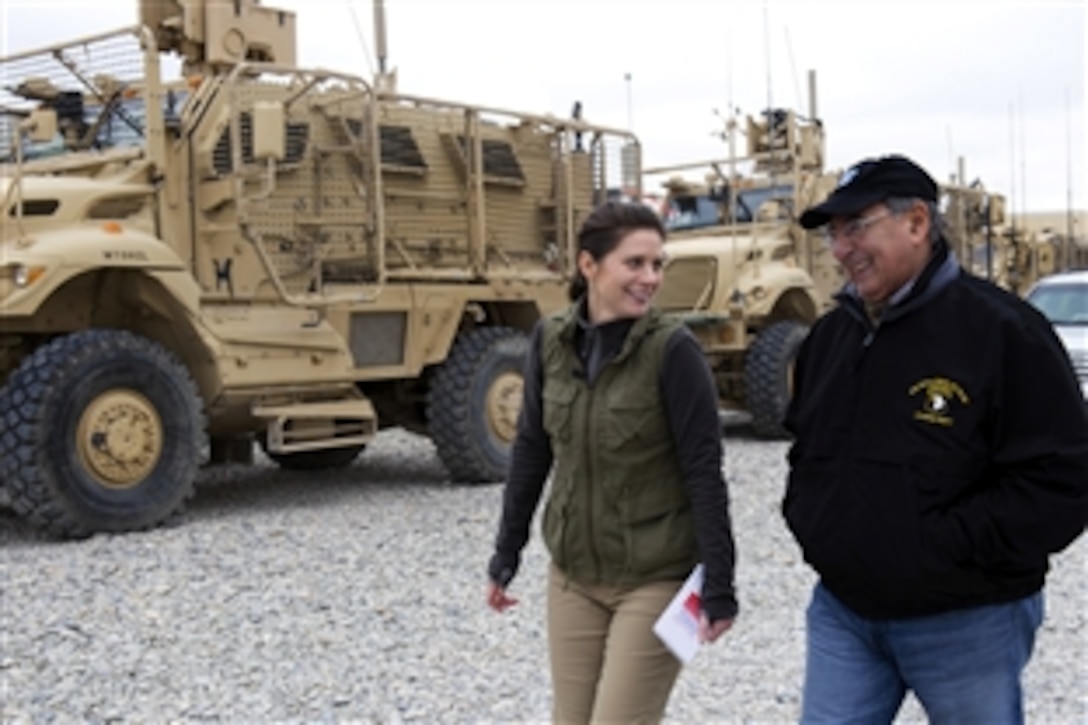 U.S. Defense Secretary Leon E. Panetta walks with Erin Burnett, CNN news anchor, during an interview in Kandahar, Afghanistan, Dec. 13, 2012. 