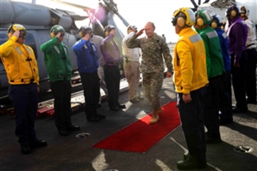 U.S. Army Gen. Martin E. Dempsey, chairman of the Joint Chiefs of Staff, walks through rainbow sideboys upon arrival to the aircraft carrier the USS John C. Stennis for a USO-sponsored holiday tour in the Arabian Sea, Dec. 13, 2012. The tour featured country music singer Kellie Pickler; Washington Nationals pitchers Ross Detwiler and Craig Stammen; Washington Capitals forward Matt Hendricks and comedian Iliza Shlesinger. 