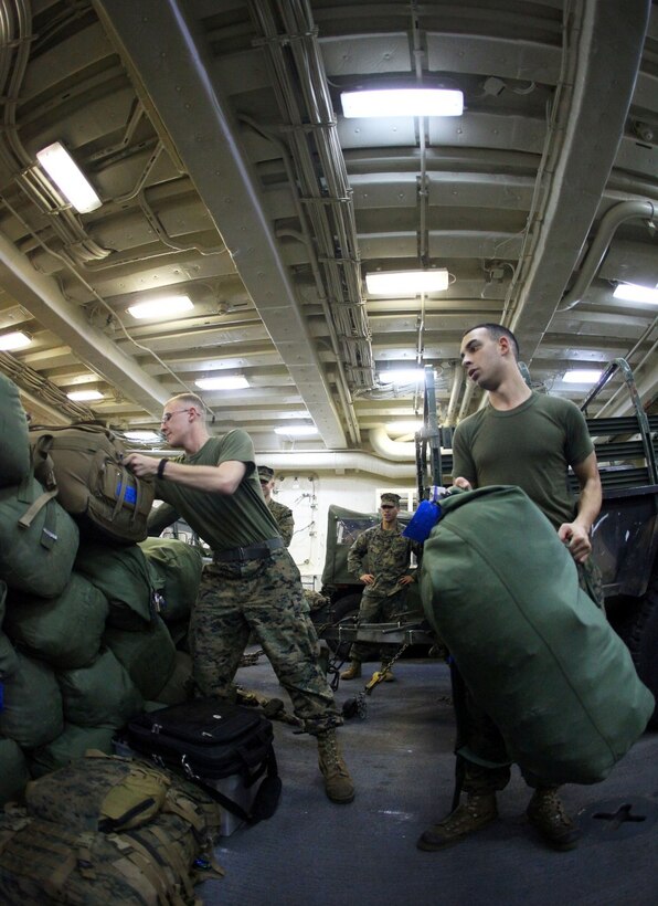 Pfc. Stephen Frame, left, and Lance Cpl. Anthony Fedga, both cannon crewmen with India Battery, Battalion Landing Team 1st Battalion, 2nd Marine Regiment, 24th Marine Expeditionary Unit, stacks baggage aboard the USS New York, Dec. 13, 2012, in preparation for the MEU's offload. The 24th MEU is returning home in time for the holidays after spending most of 2012 deployed in the U.S. Navy's 5th and 6th Fleet areas of responsibility as an expeditionary crisis response force, maintaining presence aboard the ships of the Iwo Jima Amphibious Ready Group within the U.S. Central, European and Africa Commands. (U.S. Marine Corps photo by Cpl. Michael Petersheim)