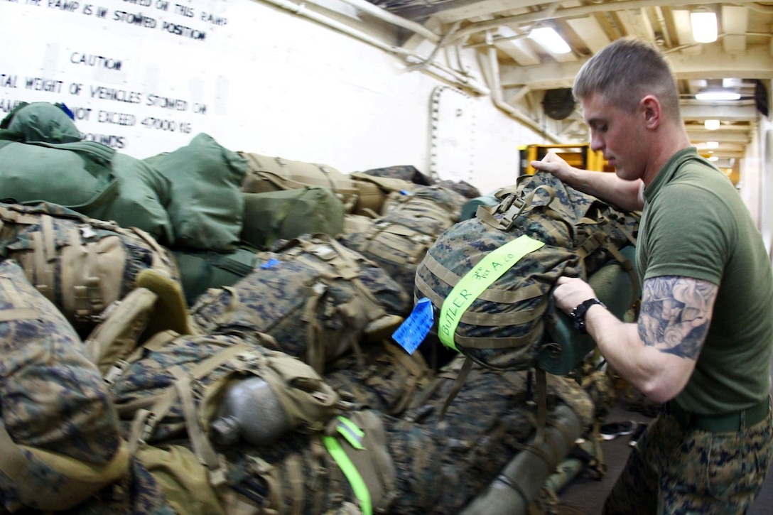 Lance Cpl. Curtis Overholt, a native of Kent, Ohio, and rifleman with Alpha Company, Battalion Landing Team 1st Battalion, 2nd Marine Regiment, 24th Marine Expeditionary Unit, stacks baggage aboard the USS New York, Dec. 13, 2012, in preparation for the MEU's offload. The 24th MEU is returning home in time for the holidays after spending most of 2012 deployed in the U.S. Navy's 5th and 6th Fleet areas of responsibility as an expeditionary crisis response force, maintaining presence aboard the ships of the Iwo Jima Amphibious Ready Group within the U.S. Central, European and Africa Commands. (U.S. Marine Corps photo by Cpl. Michael Petersheim)