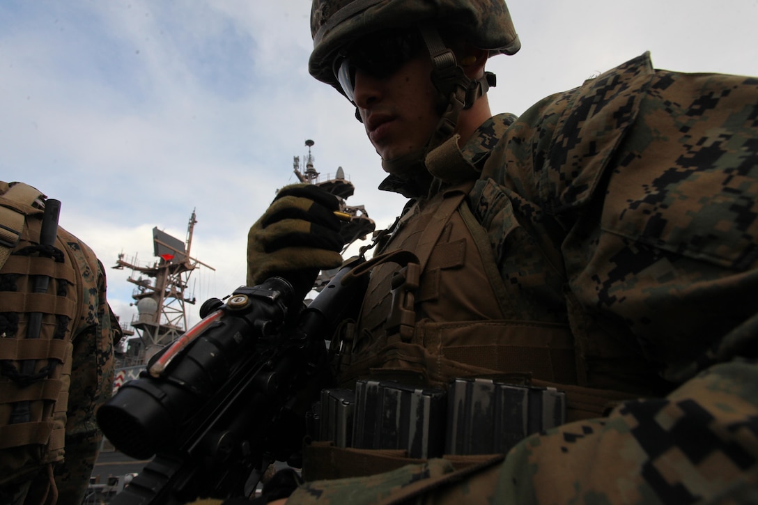 Cpl. Chris Leoni, a Naples, Fla., native with Security Platoon, Headquarters and Service Company, Battalion Landing Team 1st Battalion, 2nd Marine Regiment, 24th Marine Expeditionary Unit, makes adjustments to his M4 carbine service rifle during a live-fire training exercise on the flight deck of USS, Dec. 9, 2012. The 24th MEU is deployed with the Iwo Jima Amphibious Ready Group and is currently in the 6th Fleet area of responsibility. Since deploying in March, they have supported a variety of missions in the U.S. Central, Africa and European Commands, assisted the Navy in safeguarding sea lanes, and conducted various bilateral and unilateral training events in several countries in the Middle East and Africa. (U.S. Marine Corps photo by Lance Cpl. Tucker S. Wolf/Released)