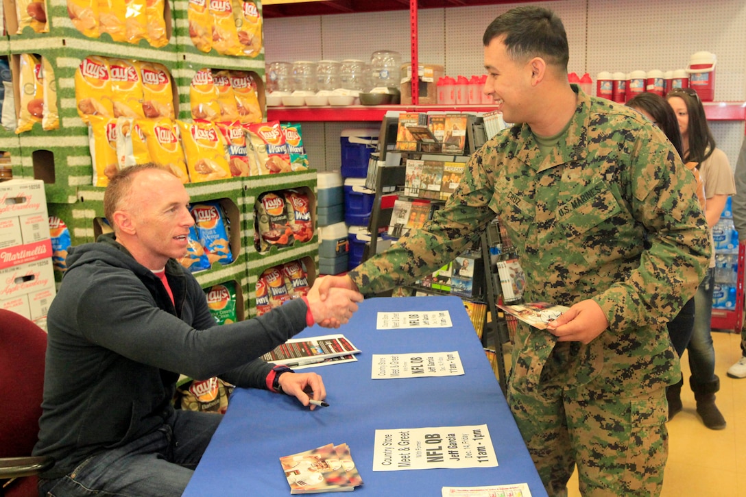 Jeff Garcia, left, autographed a photo for Sgt. Miguel Cruz, right, at the Country Store here on Dec. 14. Garcia is a former quarterback who’s played for various teams in the NFL. 
“Garcia is my buddy’s favorite quarterback,” said Cruz, a combat skills instructor here. “His wife asked if I could come and get his autograph so we could send it to her husband while he’s deployed.”
