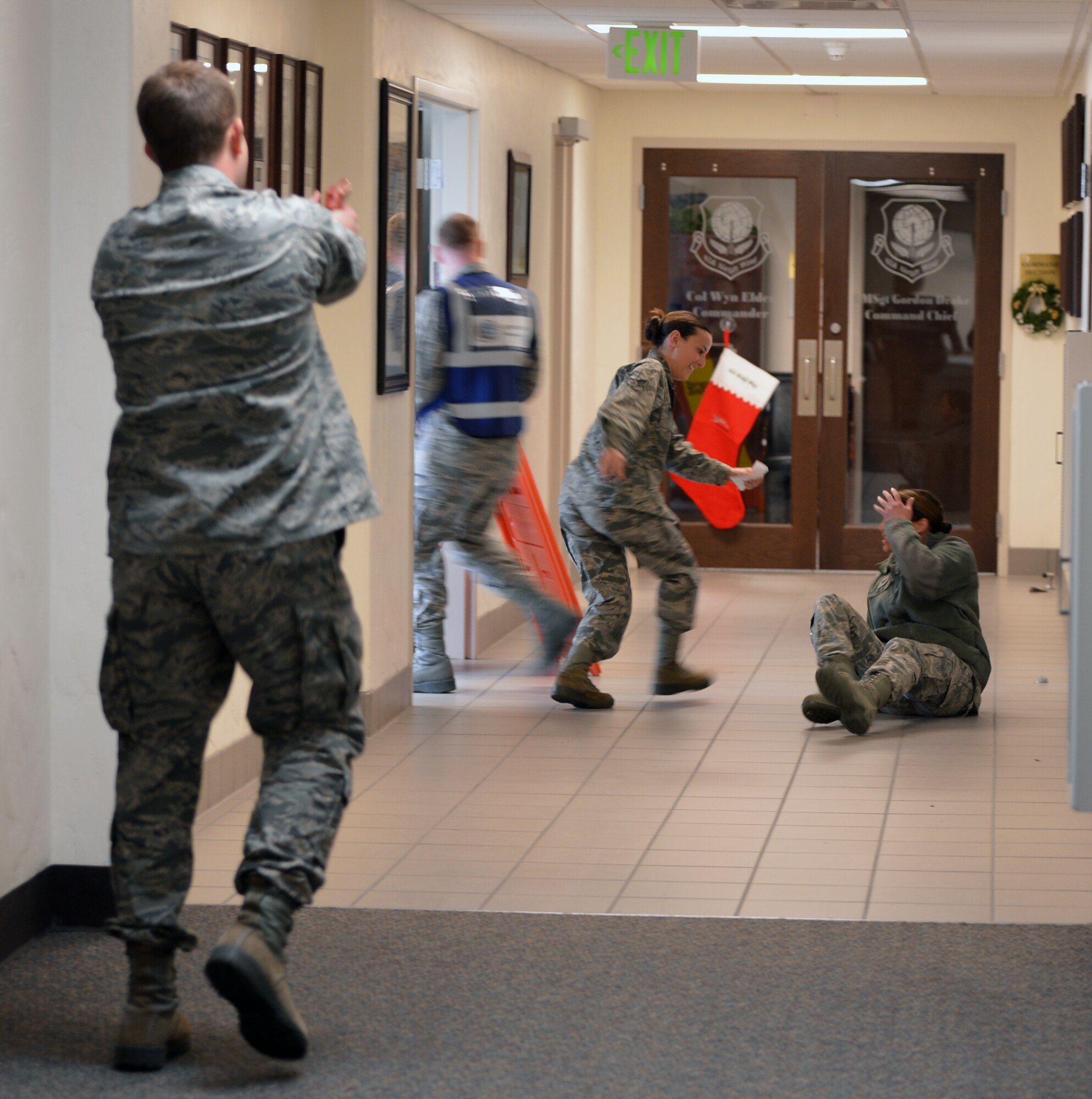 A simulated gunman and victims simulate an active shooter scenario at the command section of the 62nd Airlift Wing's headquarters building at Joint Base Lewis-McChord, Wash., Dec. 12, 2012. Base personnel were tested on their reactions to three different scenarios which were played out during the day as part of a joint basing coordinated exercise. (U.S. Air Force photo/Staff Sgt. Jason Truskowski)
