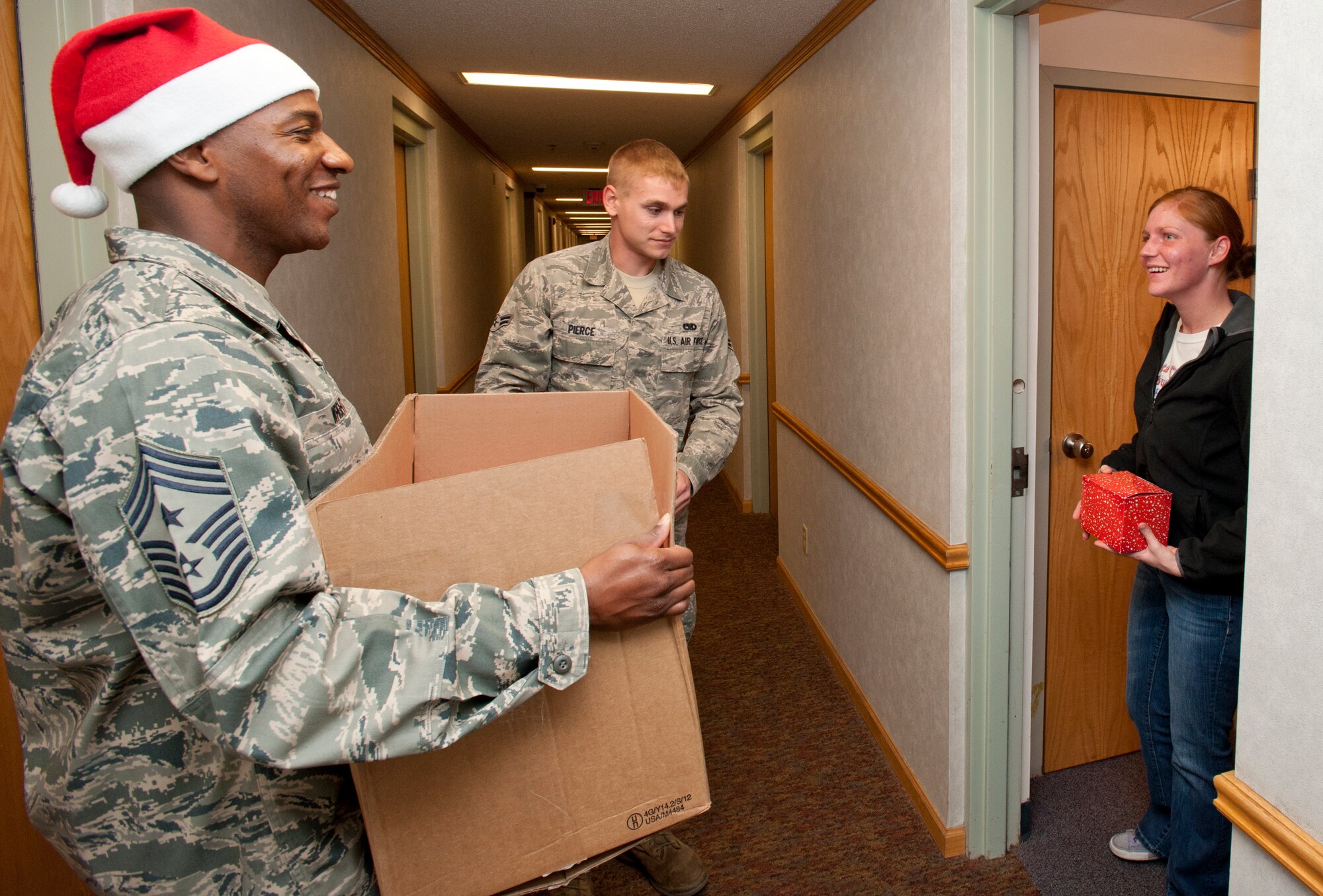 Airman 1st Class Sueann Spratt, 22nd Aircraft Maintenance Squadron electro environmental apprentice, thanks Chief Master Sgt. Kaleth Wright, 22nd Air Refueling Wing command chief, and Airman 1st Class Mason Pierce, 22nd Aircraft Maintenance Squadron KC-135 aerospace maintenance apprentice, for delivering a box of cookies to her room in the dorms Dec. 12, 2012, McConnell Air Force Base, Kan. More than 4,000 cookies were packaged and delivered to the residents of the dorms. (U.S. Air Force photo/Airman 1st Class Victor J. Caputo)