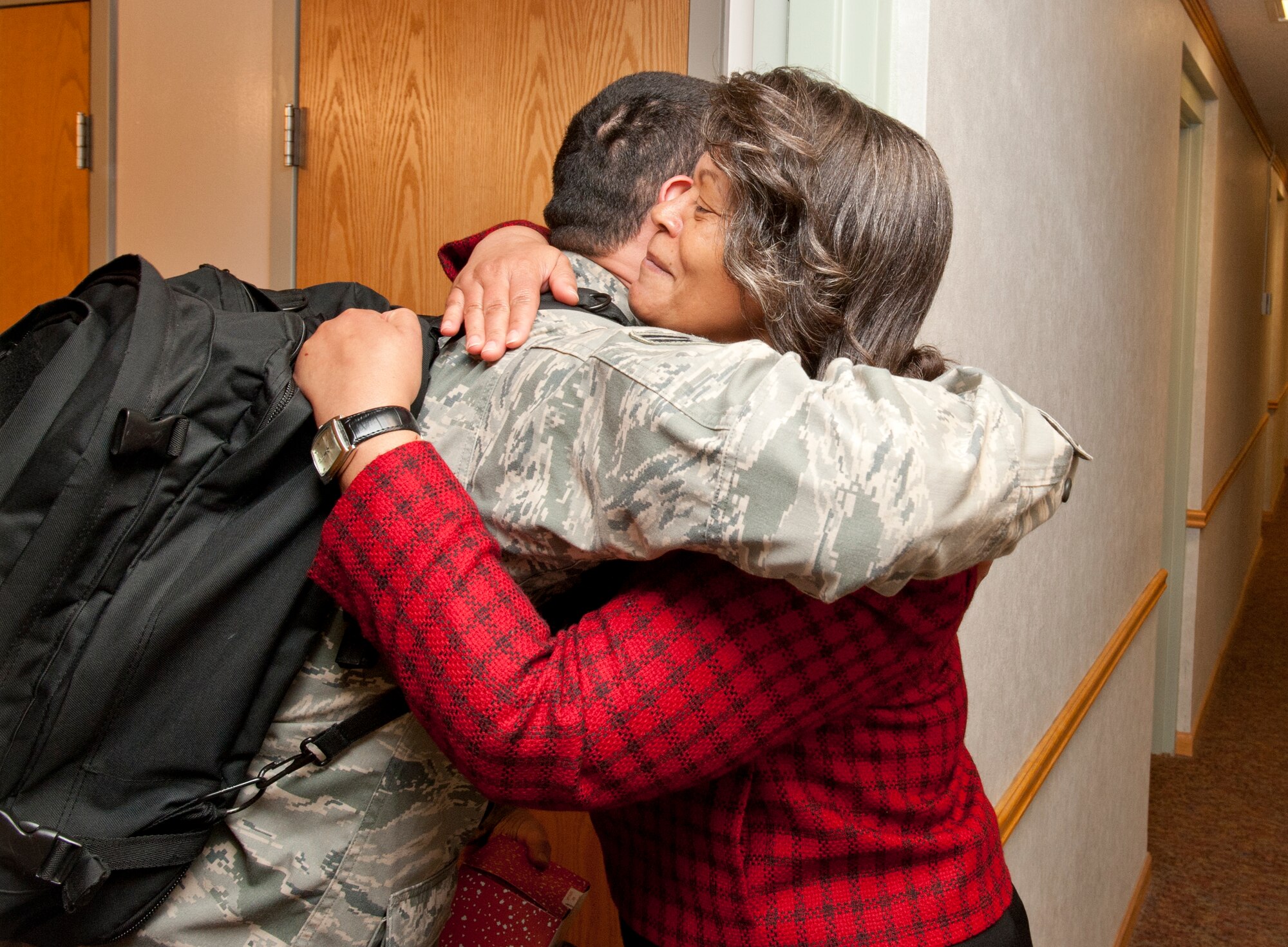Evelyn McDew hugs an Airman after she hands him a box of homemade cookies Dec. 12, 2102, McConnell Air Force Base, Kan. McDew, who was visiting the base with her husband Lt. Gen. Darren McDew, 18th Air Force commander, was able to help McConnell first sergeants, chief master sergeants and Airmen dorm staff deliver more than 4,000 cookies to the Airmen residing in the dorms. (U.S. Air Force photo/Airman 1st Class Victor J. Caputo)
