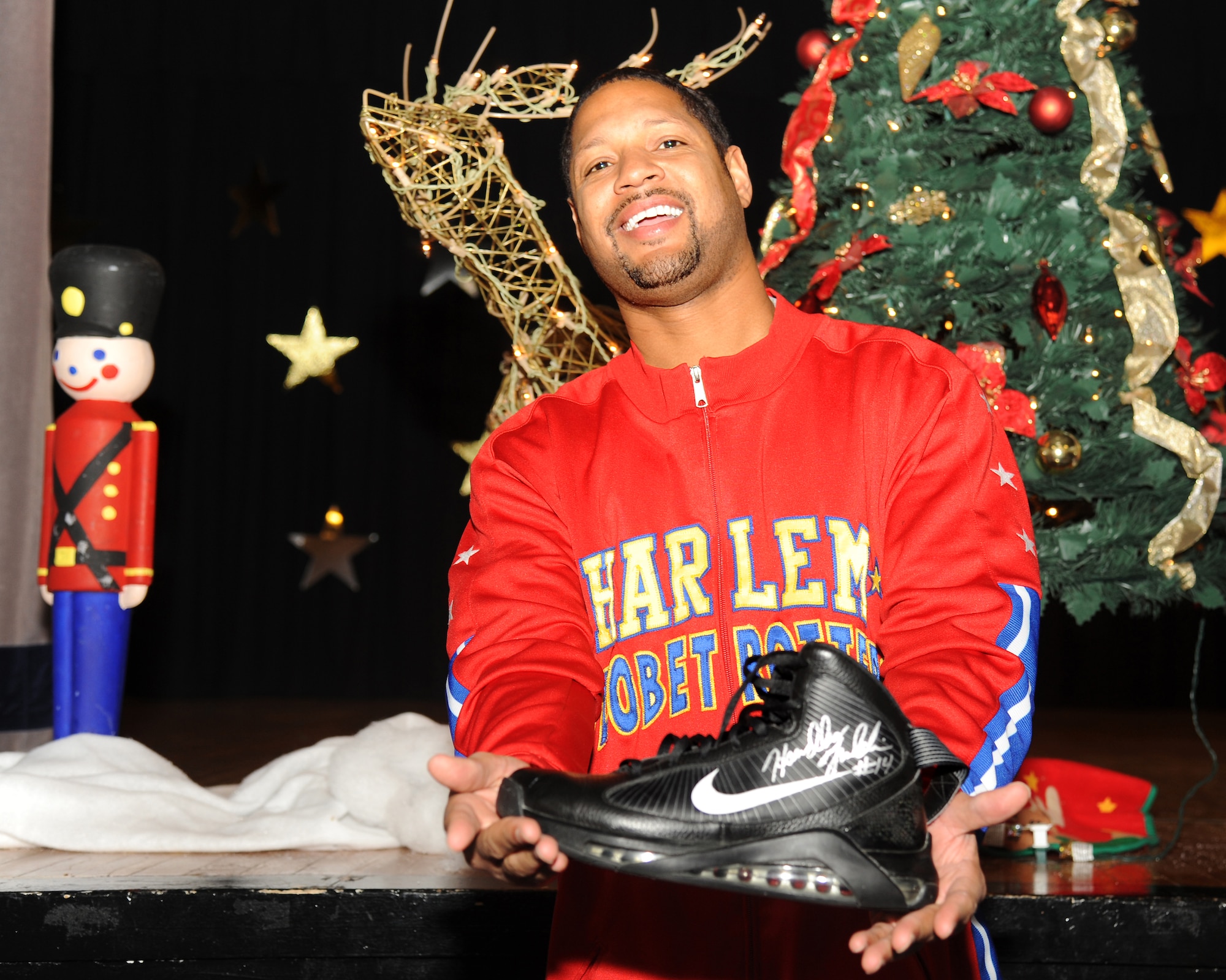 Harlem Globetrotter Chris “Handles” Franklin displays a signed shoe for a fan attending the hoopster’s Dec. 11, 2012, visit to Grand Forks Air Force Base, N.D. Handles spoke to a room full of children about “C.H.E.E.R. For Character,” a community outreach program that focuses on educating others on the importance of developing and promoting character education by motivating kids to care about school and each other in order to better prepare themselves for the challenges they will soon face as young adults. (U.S. Air Force photo/Airman 1st Class Xavier Navarro)
