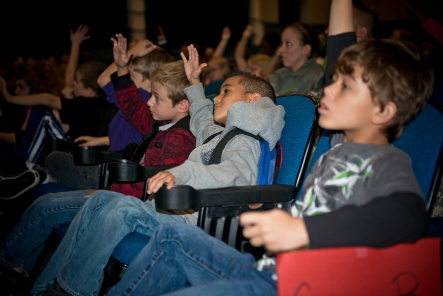 Children raise their hands during the Moody Youth Program’s Recognition Ceremony at Moody Air Force Base Ga., 12 Dec. 2012. The children were recognized for their outstanding achievements in multiple activities, including a Crime Scene Investigation Camp and other volunteer efforts. (U.S. Air Force photo by Senior Airman Douglas Ellis/Released) 
