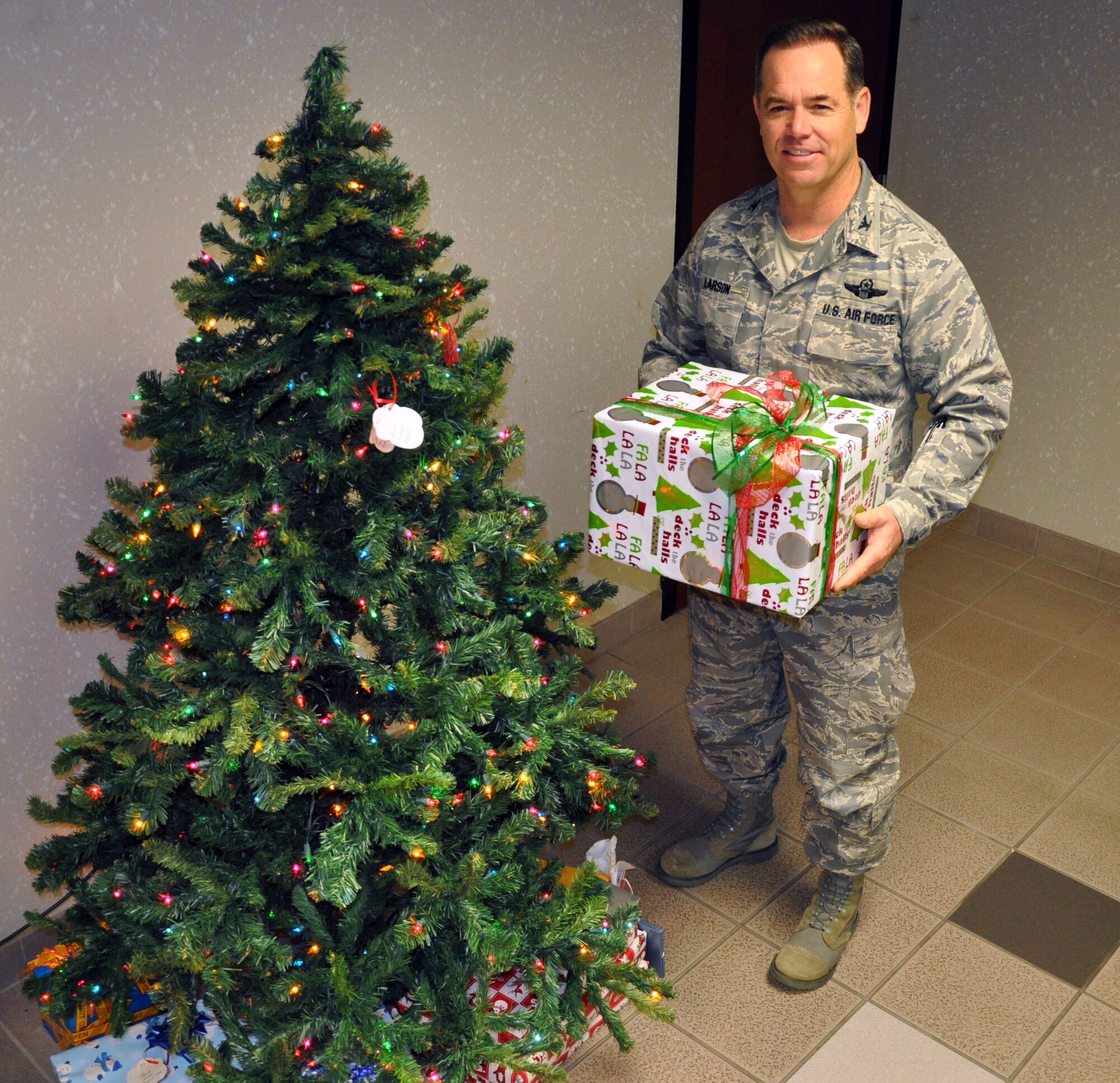 Col. Mark S. Larson, commander of the 931st Air Refueling Group, McConnell Air Force Base, Kan., stands next to the 931st Air Refueling Group Angel Tree with a box of donations from the Robert J. Dole Veterans Medical Center, Dec. 14, 2012.  The staff of at the medical center hosted a holiday open house and collected donations for McConnell Airmen in need during the holiday season.  The donations will go to help out the 931st Angel Tree program.  (U.S. Air Force photo by 1st Lt. Zach Anderson)