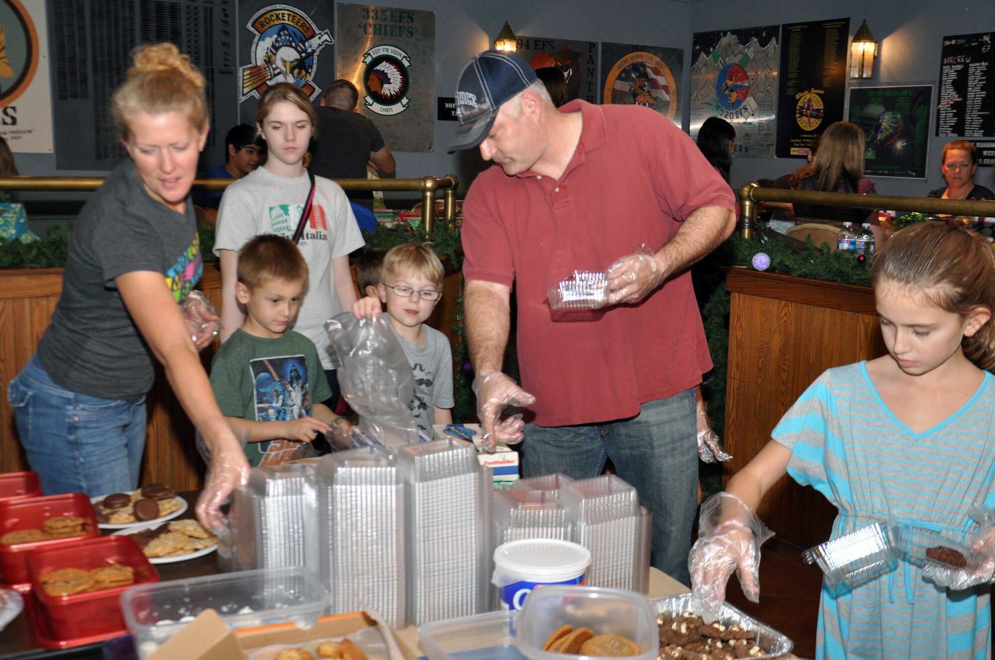 U.S. Air Force Lt. Col. David Moeller, 335th Fighter Squadron commander, shows children volunteers what to do during a cookie drive on Seymour Johnson Air Force Base, N.C., Dec. 10, 2012. The drive was set up to support Airmen living in the dorms who may be away from their families for the first time and to spread holiday cheer. (U.S. Air Force photo/Airman 1st Class Mariah Tolbert/ Released)