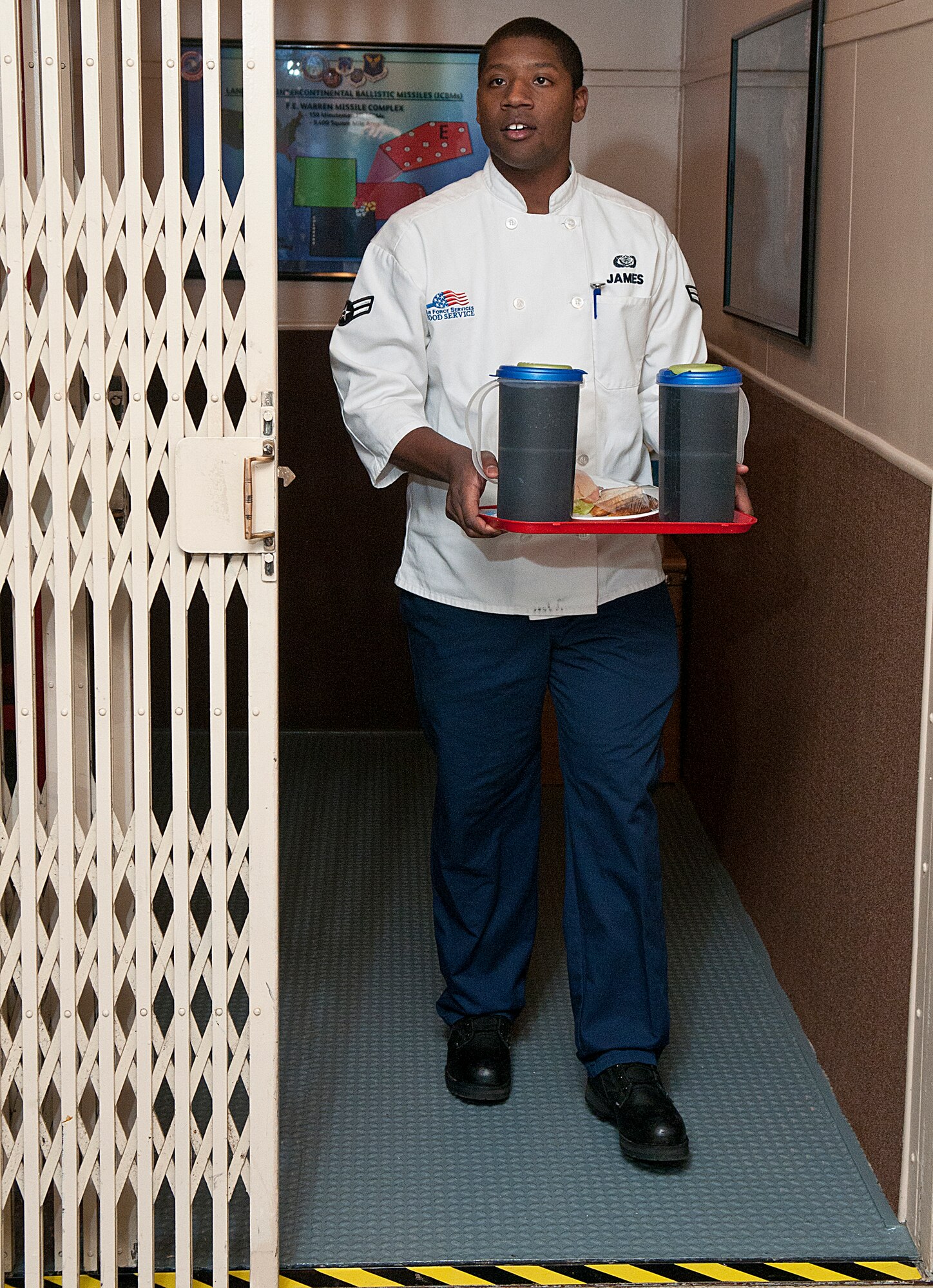 Airman 1st Class Davell James, 319th Missile Squadron chef, brings lunch down for the missile crew in the launch control capsule below Missile Alert Facility Echo-1 Nov. 28. (U.S. Air Force photo by R.J. Oriez)