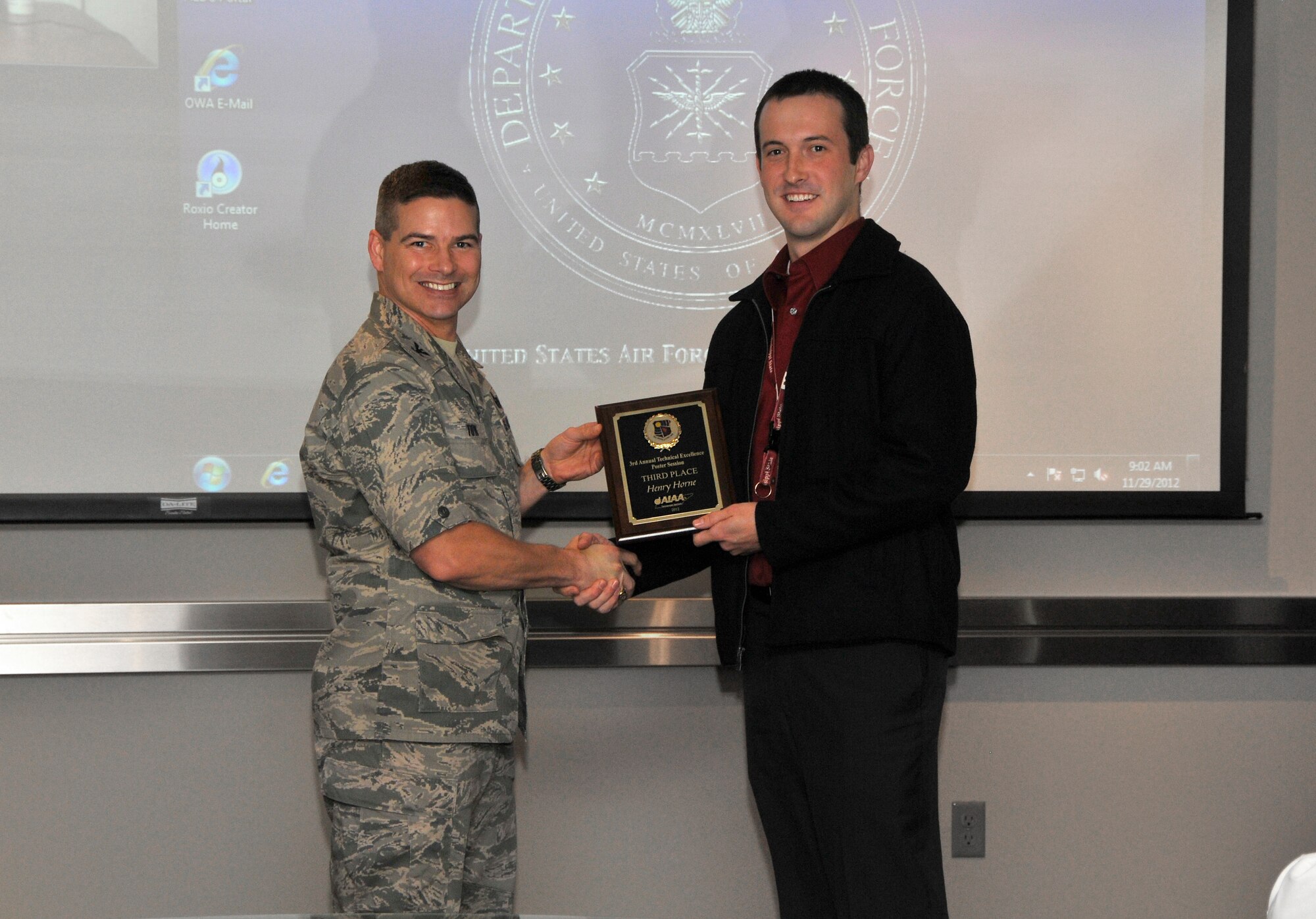 AEDC Engineer Henry Horne (right) receives a third place Technical Excellence Poster Session award from presenter Col. Raymond Toth, AEDC commander. (Photo by Jacqueline Cowan)