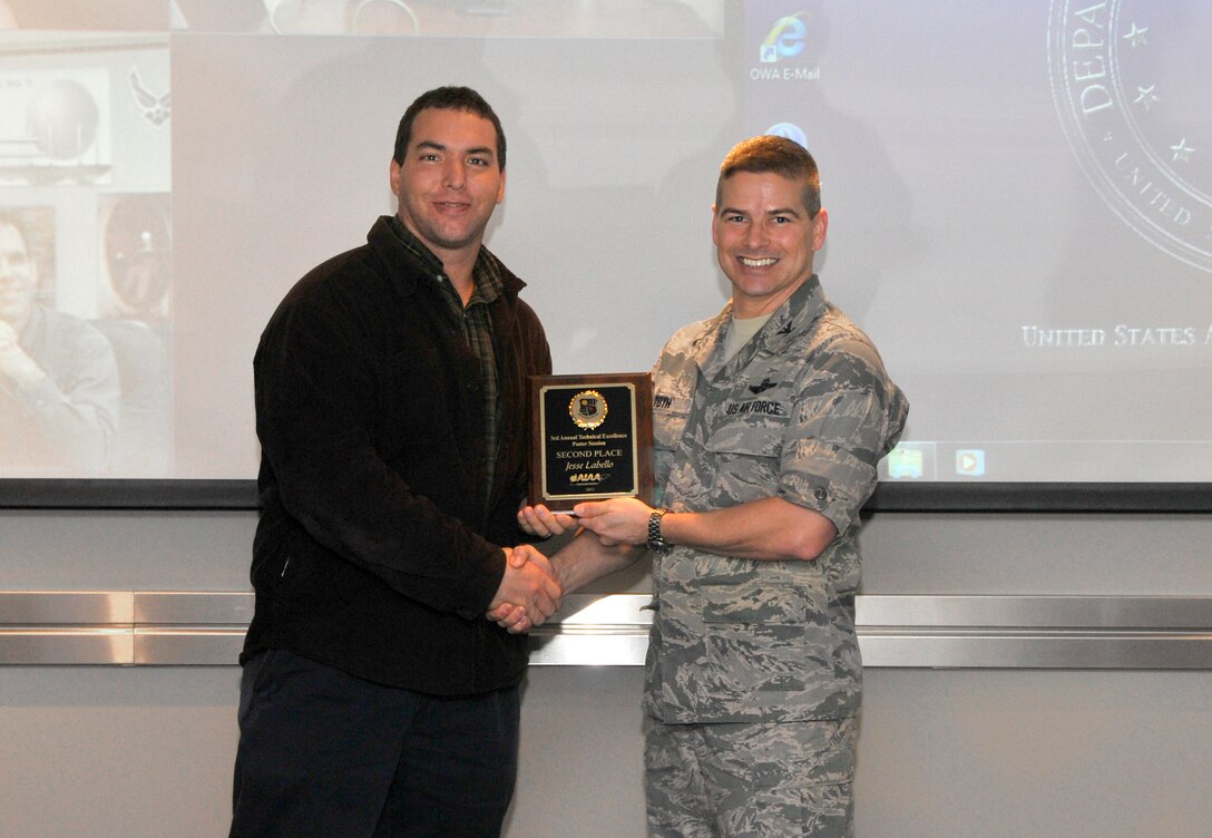 AEDC Engineer Jesse Labello (left) receives a second place Technical Excellence Poster Session award from presenter Col. Raymond Toth, AEDC commander. (Photo by Jacqueline Cowan)