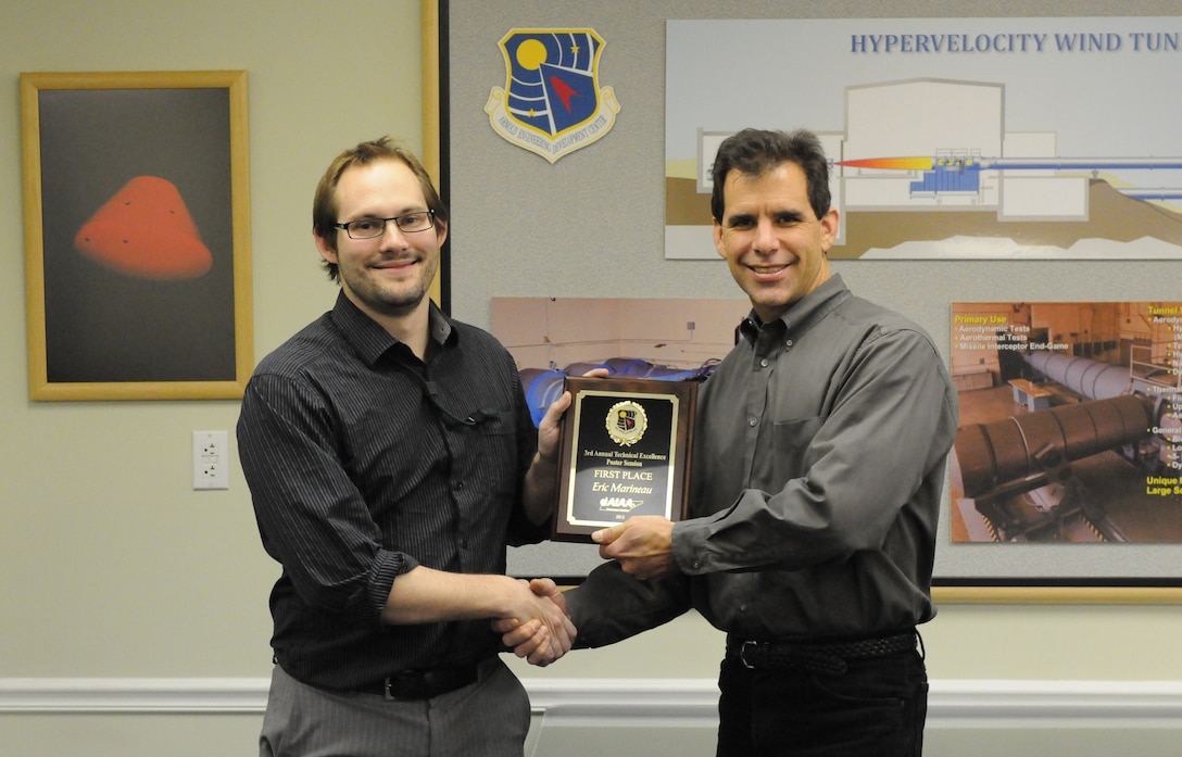 Eric Marineau (left), an AEDC Hypervelocity Tunnel 9 engineer, receives a first place Technical Excellence Poster Session award from presenter Dan Marren, AEDC Hypervelocity Tunnel 9 director. (Photo by Arnold Collier)