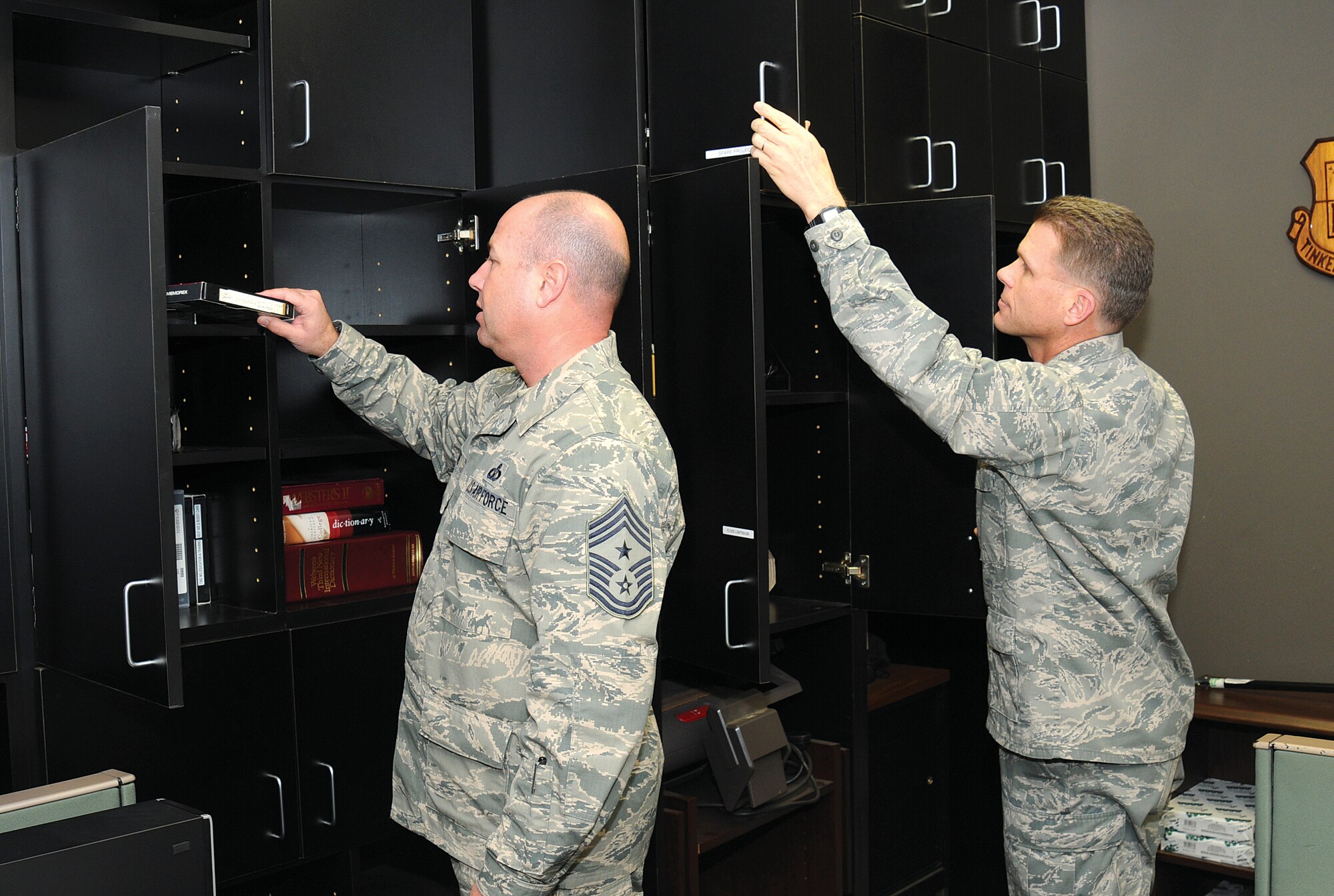 Inspecting common areas of the 72nd Air Base Wing Headquarters in Bldg. 460, Command Chief Master Sgt. Brian Lavoie and Commander Col. Steven Bleymaier look through cabinets of a media preparation room. Directed by Chief of Staff of the Air Force Gen. Mark A. Welsh III, the health and wellness inspections are being carried out Air Force-wide as leaders strive to ensure their work areas create a healthy environment for everyone to carry out the mission. In a release last week the Air Force said, “The purpose of this inspection is to reinforce expectations for the workplace environment, correct deficiencies, and deter conditions that may be detrimental to good order and discipline. Commanders will look for and remove unprofessional or inappropriate items that hinder a professional working environment.” Areas used by all are the only places leadership will open drawers and cabinets. Personal areas including offices, desks and toolboxes will not be opened during the inspections. (Air Force photo by Margo Wright)