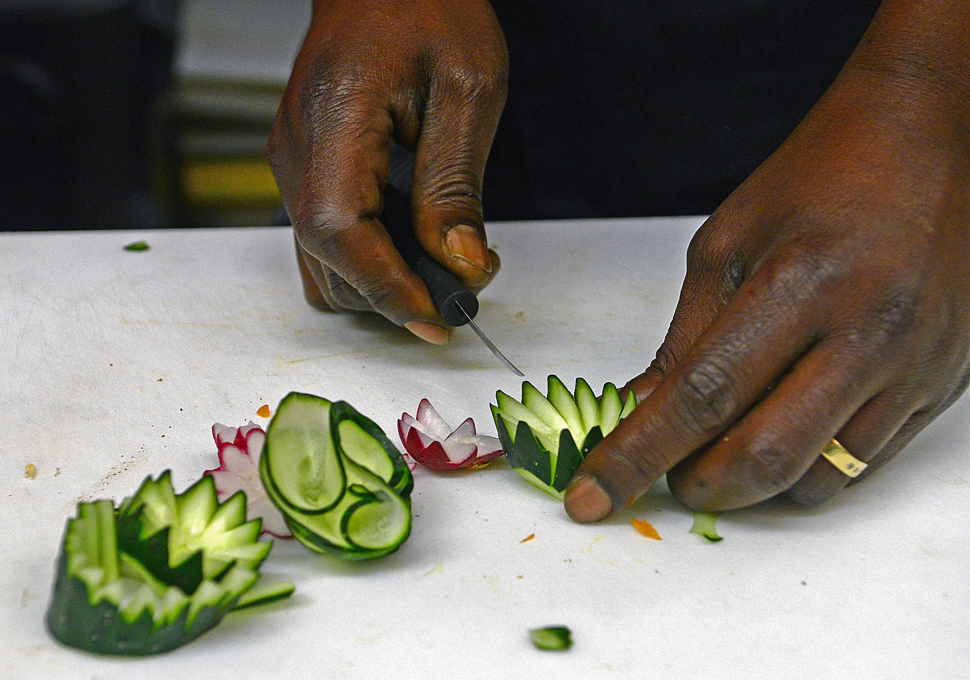 James Griggs, 31st Force Support Squadron cook, designs flowers using vegetables, Dec. 14, at the La Bella Vista Club at Aviano Air Base, Italy.  The La Bella Vista Club staff is planning new programs and services for Aviano Airmen and their families in the upcoming year. (U.S. Air Force photo by Airman 1st Class Matthew Lotz)