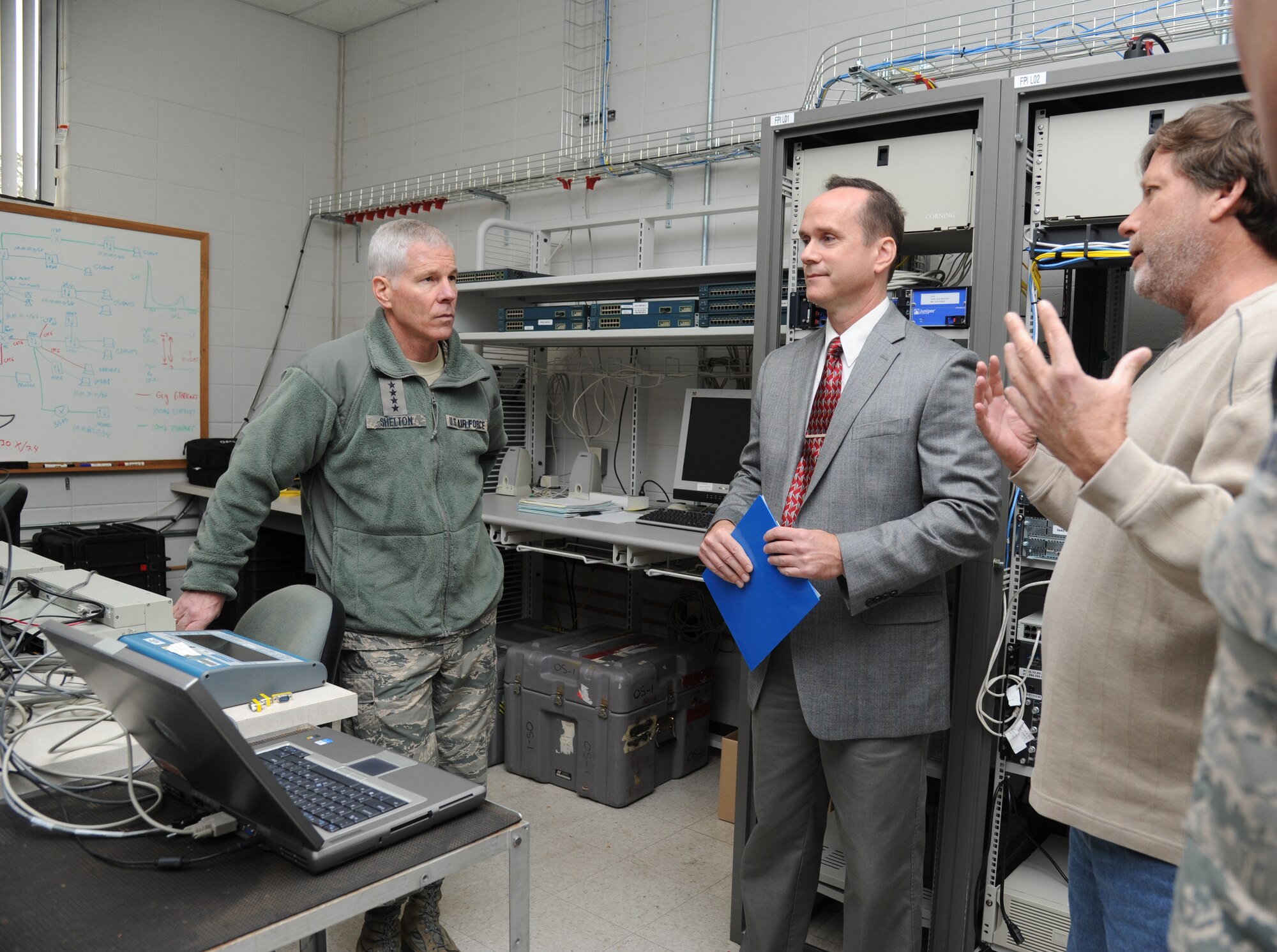 General William Shelton, Air Force Space Command commander, talks with Kent Massey and Barry St. Amant, 85th Engineering Installation Squadron, about airfield systems upgrade equipment during a tour of the squadron, Dec. 11, 2012, at Keesler Air Force Base, Miss. General Shelton visited Keesler to see firsthand how a high deployment rate affects the 85th EIS and how the squadron contributes to the Air Force mission.  (U.S. Air Force photo by Kemberly Groue)