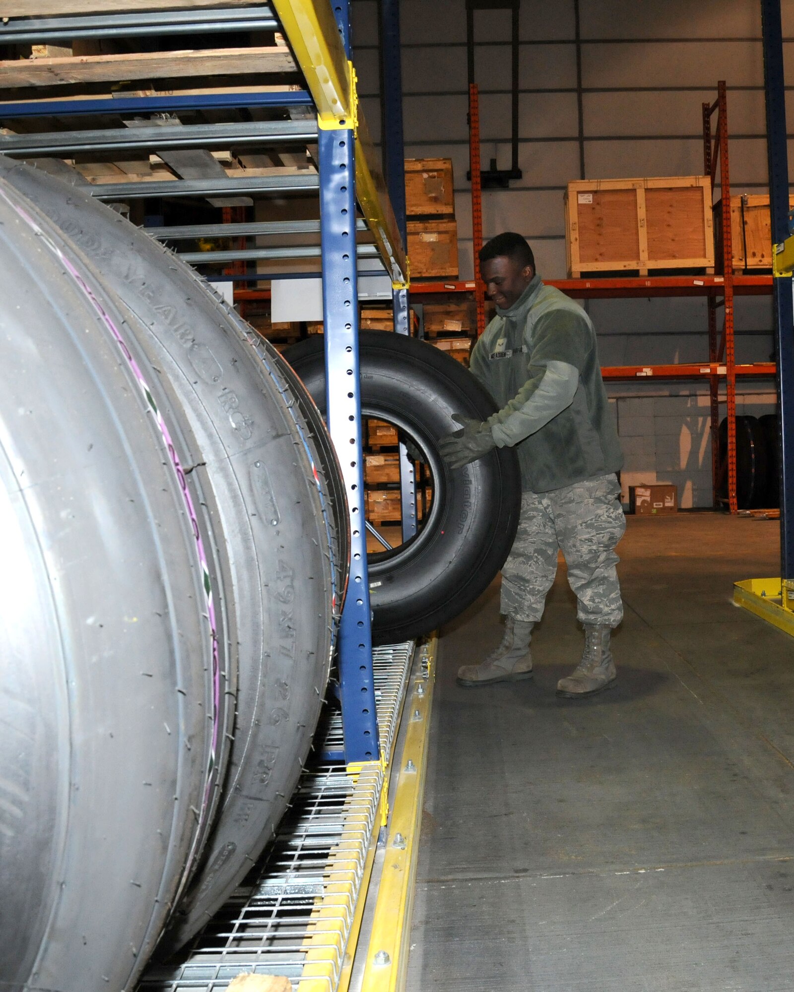 Airman 1st Class Harry McFadden, 100th Logistics Readiness Squadron aircraft parts store technician, from Columbia, S.C., moves a tire to a new location Dec. 14, 2012, at RAF Mildenhall, England. The section operates 24-hours-a-day, 7-days-a-week to meet mission requirements. (U.S. Air Force photo by Gina Randall/Released)