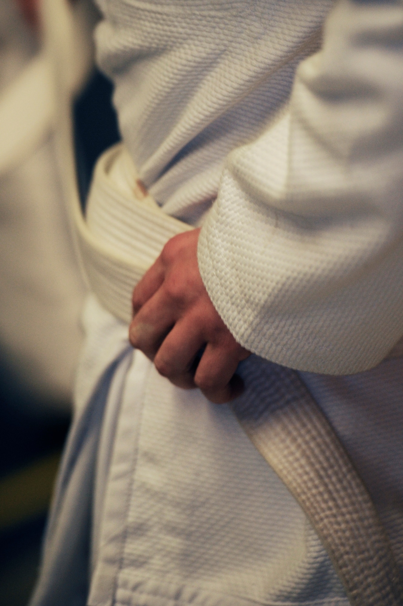 A student of the Brazilian Jiu-jitsu class ties his gi during a class Rhines Ordnance Barracks, Germany, Nov. 26, 2012. Students here go over different self-defense techniques. Many different people come through the class all with different skill levels.  Some people practice Jujitsu for the technique, others for fitness or even just for self-defense. Classes are every Monday and Wednesday at 6 p.m. to 8 p.m. (U.S. Air Force photo/ Senior Airman Aaron-Forrest Wainwright)