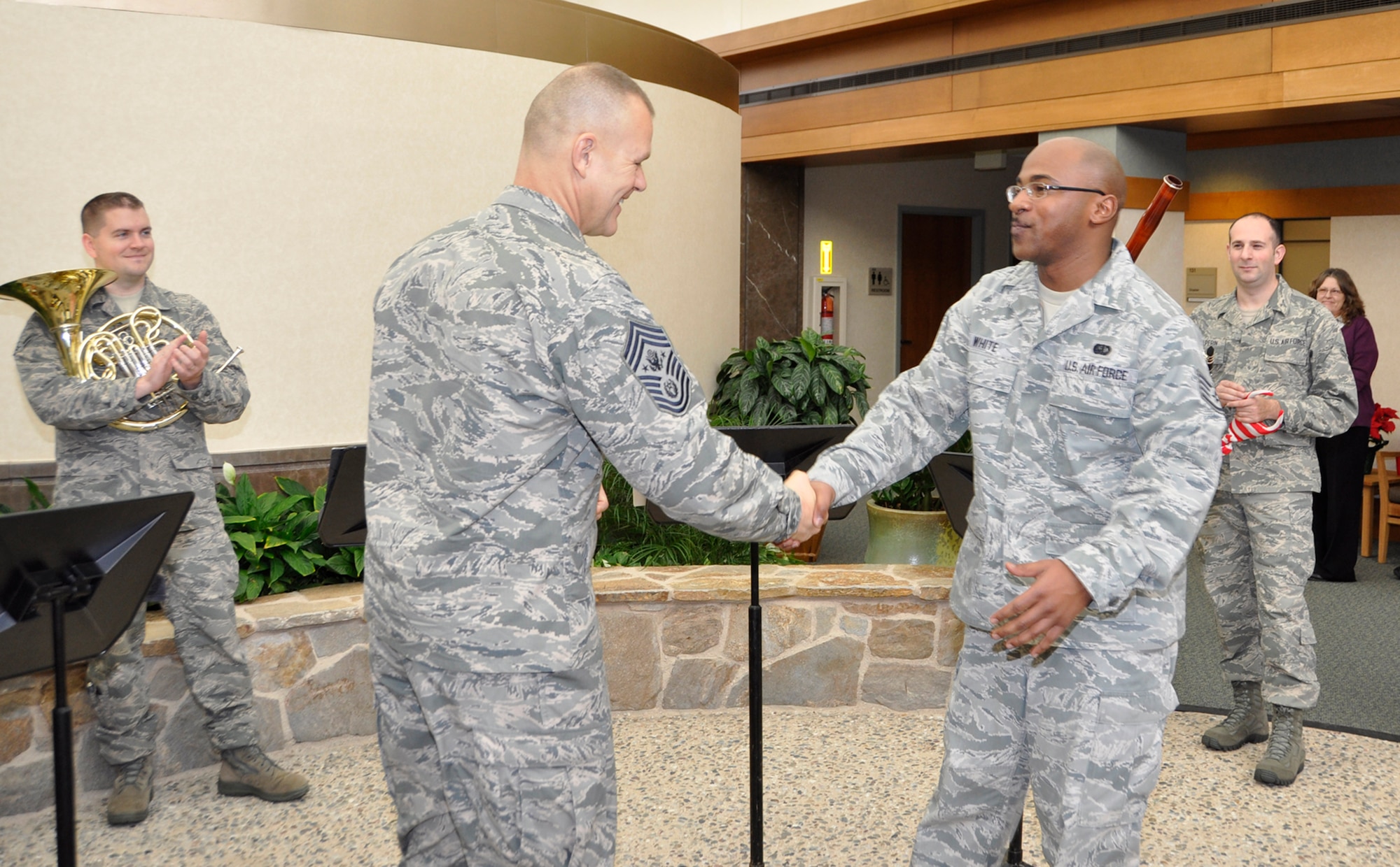 Chief Master Sgt. of the Air Force James A. Roy coins Staff Sgt. William White, 512th Memorial Affairs Squadron, for his work at the mortuary. Roy came to the Charles C. Carson Center for Mortuary Affairs as part of his farewell tour Dec. 12, 2012, to thank the men and women for their service to fallen heroes and their families. Roy, the 16th Chief Master Sergeant of the Air Force, will retire next month after more than 30 years of service. (U.S. Air Force photo/Master Sgt. Cherie McNeill)
