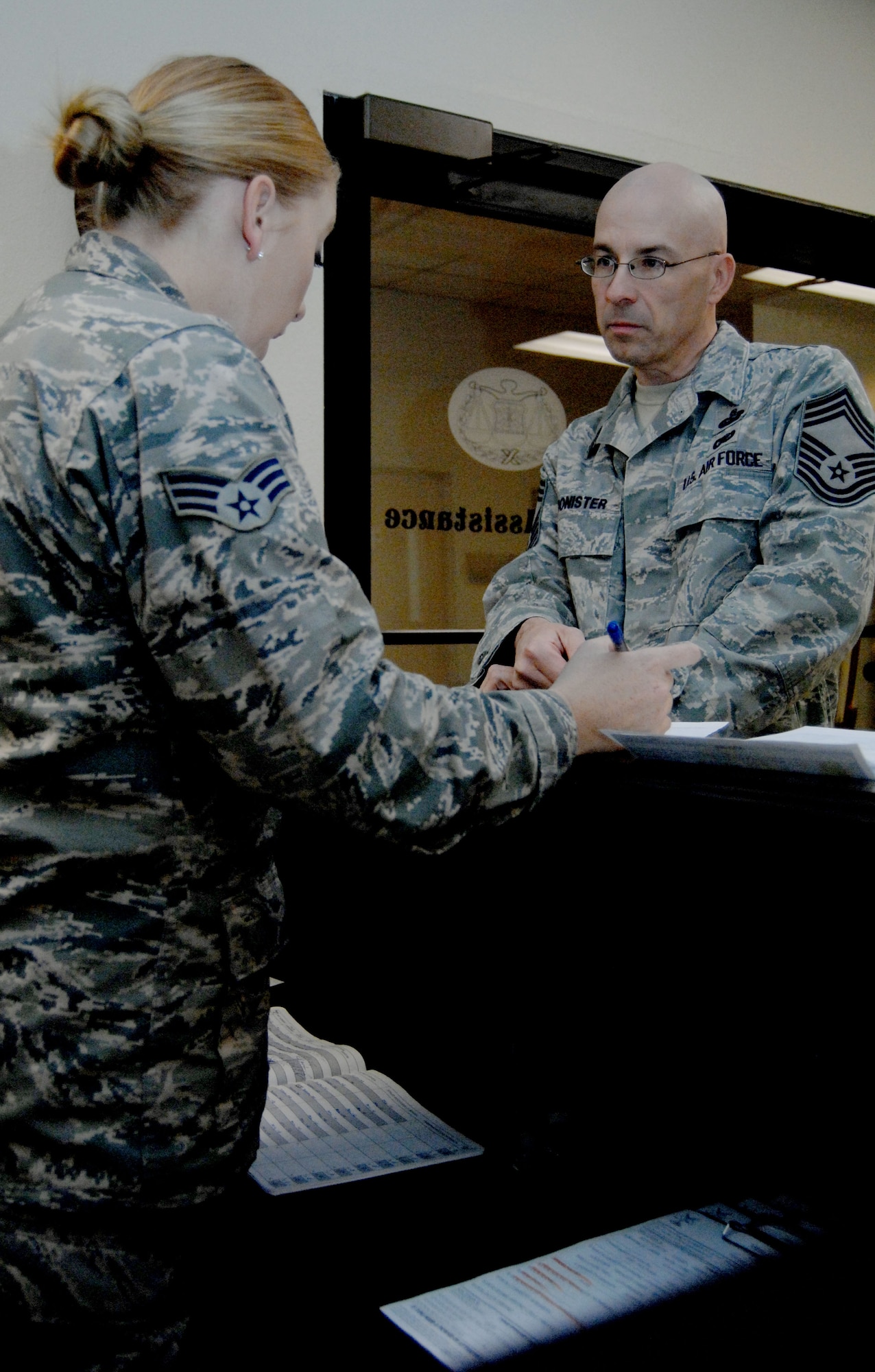 A U.S. Air Force chief master sergeant speaks with Senior Airman Alyssa Crew, 355th Fighter Wing Legal Office paralegal, about creating a Power of Attorney in the Legal Assistance section on Davis-Monthan Air Force Base, Ariz., Dec. 10, 2012. The most common legal documents processed through Legal Assistance are In Lieu of Tax Forms and Power of Attorneys. (U.S. Air Force photo by Airman 1st Class Saphfire Cook)