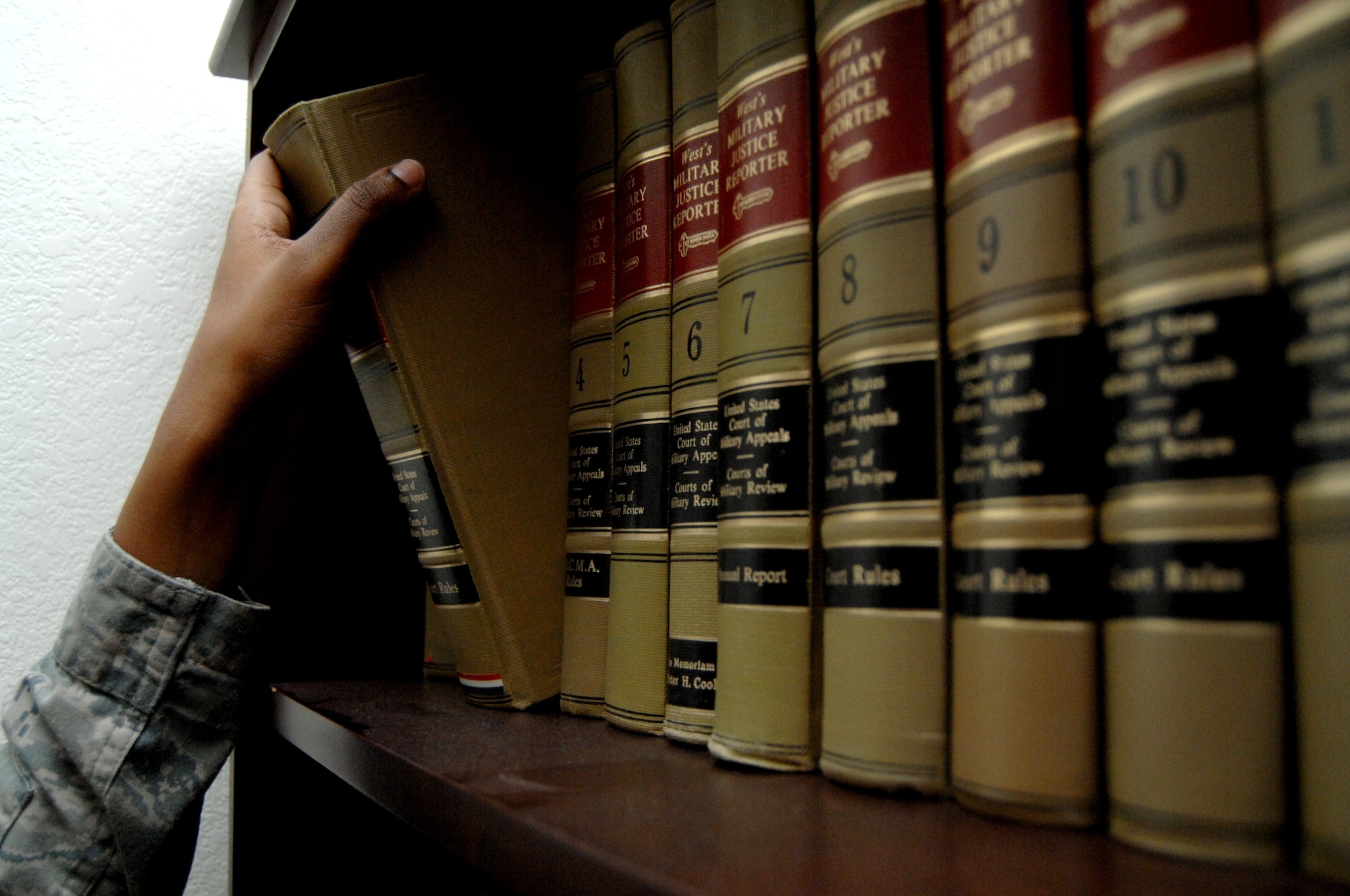 A U.S. Air Force paralegal from the 355th Fighter Wing Legal Office selects an edition of The Military Justice Reporter on Davis-Monthan Air Force Base, Ariz., Dec. 10, 2012. A bookcase in the Legal Office filled with editions of the Military Justice Reporter is known as the 'law library", and is used to research case law. (U.S. Air Force photo by Airman 1st Class Saphfire Cook)